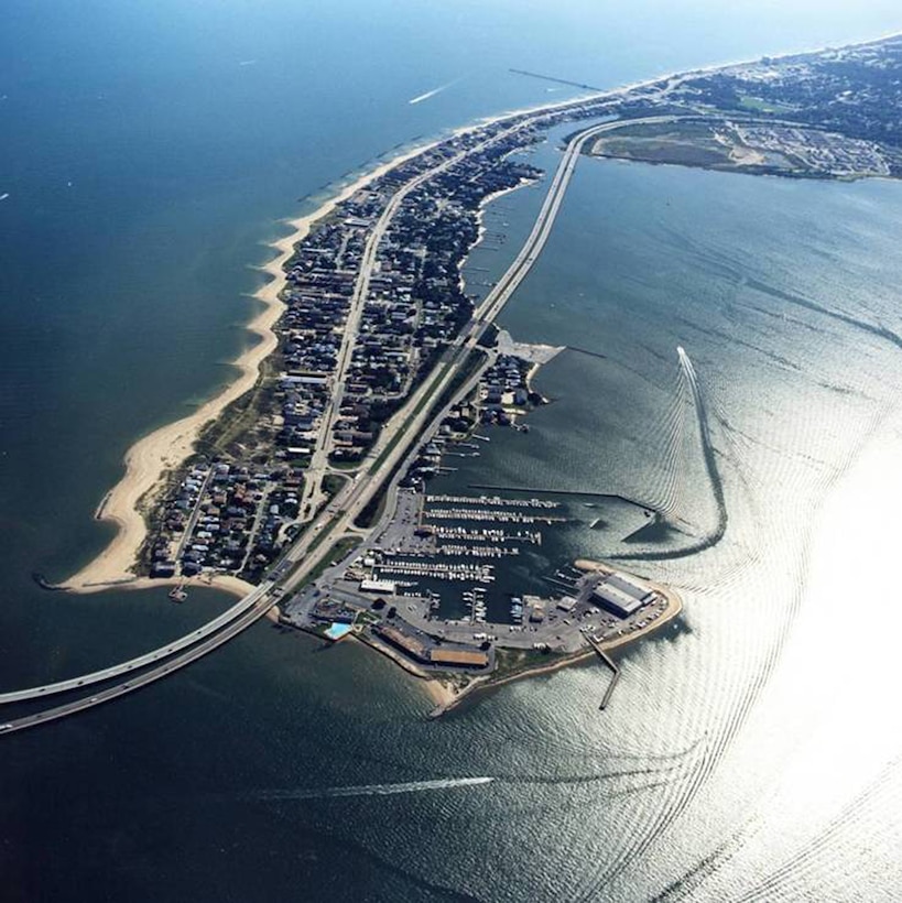 Aerial view of project area. The Authorized Project consisted of the construction and periodic sand renourishment of a protective beach berm along the entire study area shoreline.  Preconstruction Engineering and Design (PED) investigations leading to the construction of the Authorized Project were put on hold from the mid-1990s to the early 2000s due to a shift in local priorities in the study area resulting from the construction of two major Navy dredging/sand placement projects and state funding for the construction of offshore breakwaters.  In 2003, Hurricane Isabel brought about a renewed interest in the Authorized Project and with support at the local and Federal levels, PED investigations restarted to include the completion of a limited reevaluation study to determine whether there was continued Federal and local interest in the construction of the Authorized Project or a reformulated project plan.
