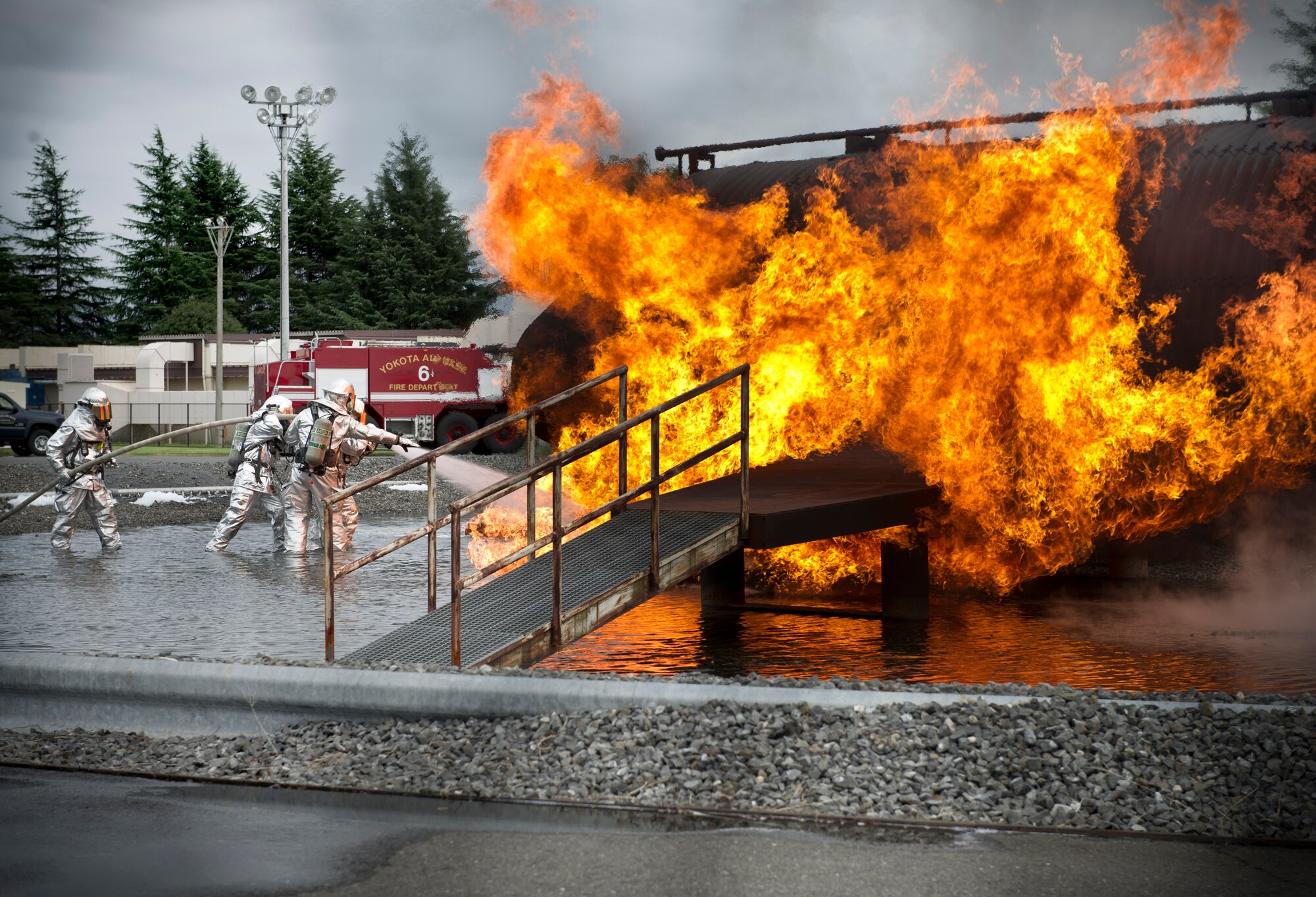 374th Airlift Wing leadership and Firefighters from the 374th Civil Engineer Squadron extinguish a fire on a simulated aircraft, Sept. 26, 2013, during a live-fire training at Yokota Air Base, Japan. The firefighters participate in this type of training to keep their skills sharp and always stay ready for fire emergencies. (U.S. Air Force photo/ Staff Sgt. Stacy Moless/released)