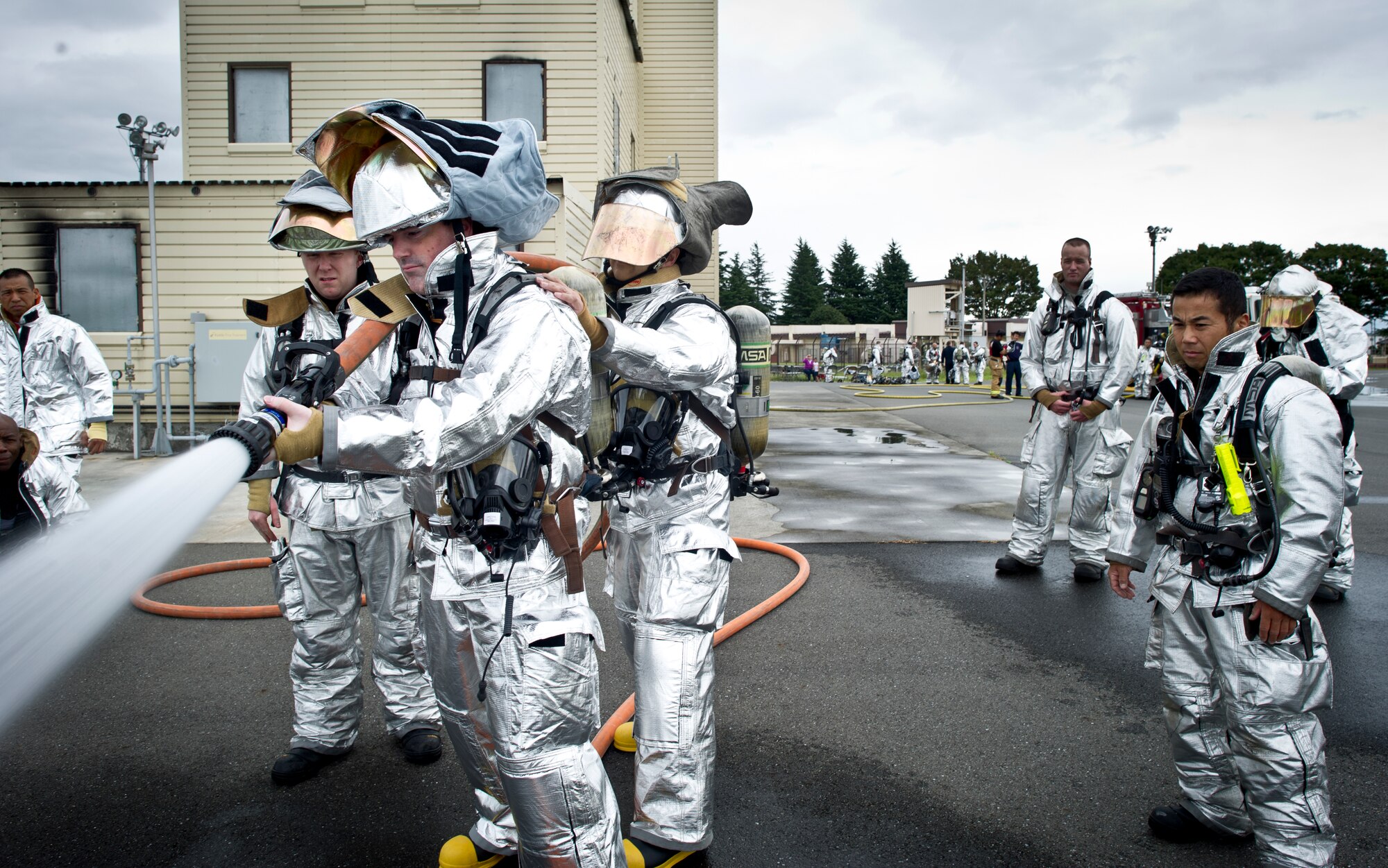 Col. Mark August, 374th Airlift Wing commander, practices using a fire hose during live-fire training Sept. 26, 2013, at Yokota Air Base, Japan. Firefighters conduct a variety of training almost every day as a part of their normal workday, and on this day Wing leadership was able to experience what fighting a fire is like. (U.S. Air Force photo by Staff Sgt Stacy Moless/released)