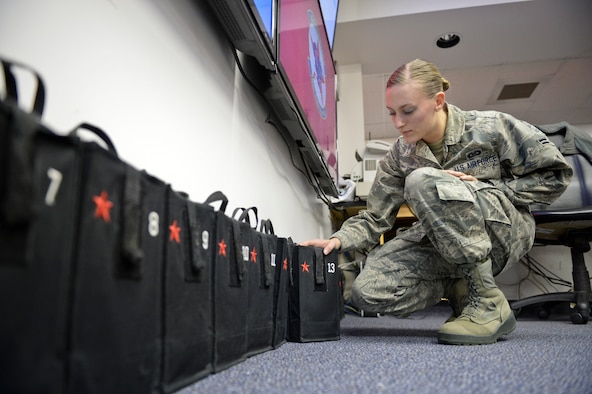U.S. Air Force Airman 1st Class Kierrea Clary, 18th Aggressor Squadron aviation resource manager, organizes packages containing terminal procedure publications at 18th AGRS headquarters Sept. 24, 2013, Eielson Air Force Base, Alaska. Clary supplied pilots with materials providing critical survival information to be used in the event of in-flight emergencies. (U.S. Air Force photo by Airman 1st Class Peter Reft/Released) 