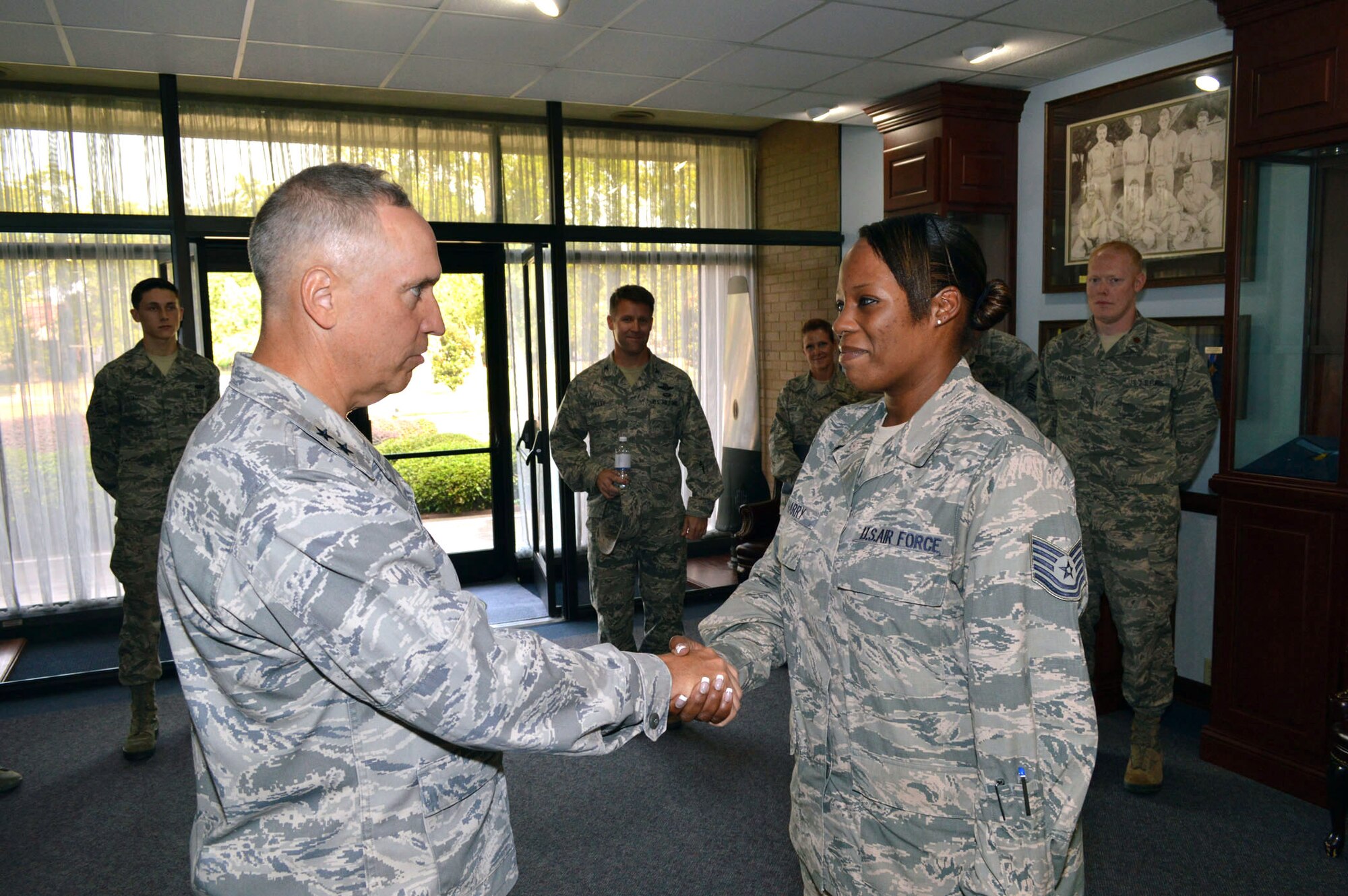 Maj. Gen. Rick Martin, U.S. Air Force Expeditionary Center commander, presents Tech. Sgt. Helen Wharry, 43d Airlift Group Knowledge Operations Management, with his coin during his tour of 43d Airlift Group units Sep 16.  As a database expert, Sergeant Wharry re-engineered the group’s performance report tracking database program, trained 52 personnel, and activated 20 cells of the group’s metrics report card in 3 months. Her efforts led the group to lead Air Mobility Command units for on-time evaluations.  General Martin visited Pope Army Airfield, N.C. to see first-hand how the 43d Airlift Group Airmen support the Global Response Force mission.  (U.S. Air Force Photo/Marvin Krause)
