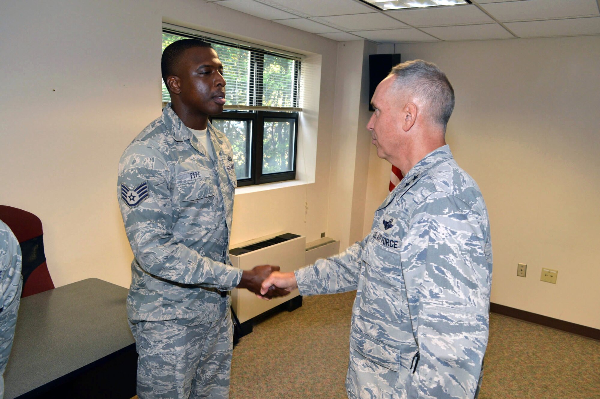 Maj. Gen. Rick Martin, U.S. Air Force Expeditionary Center commander, presents Staff Sgt. Datuan Fitz, 43d Force Support Squadron, with his coin during his tour of 43d Airlift Group units Sep 16.  Sergeant Fitz is solely responsible for updating and forwarding 1,490 case management system updates to the Air Force Personnel Center.  Additionally, his office leads the evaluations on-time rate in Air Mobility Command.  General Martin visited Pope Army Airfield, N.C. to see first-hand how the 43d Airlift Group Airmen support the Global Response Force mission.  (U.S. Air Force Photo/Marvin Krause)