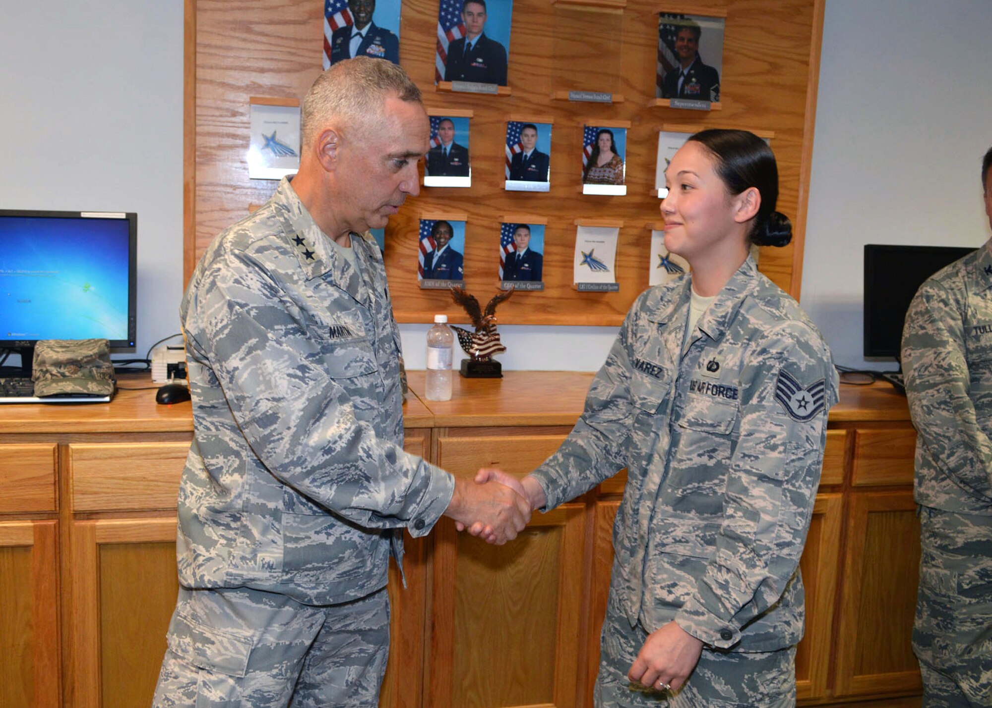Maj. Gen. Rick Martin, U.S. Air Force Expeditionary Center commander, presents Staff Sgt. Amanda Alvarez, 43d Comptroller Flight, with his coin during his tour of 43d Airlift Group units Sep 16.  General Martin visited Pope Army Airfield, N.C. to see first-hand how the 43d Airlift Group Airmen support the Global Response Force mission.  (U.S. Air Force Photo/Marvin Krause)