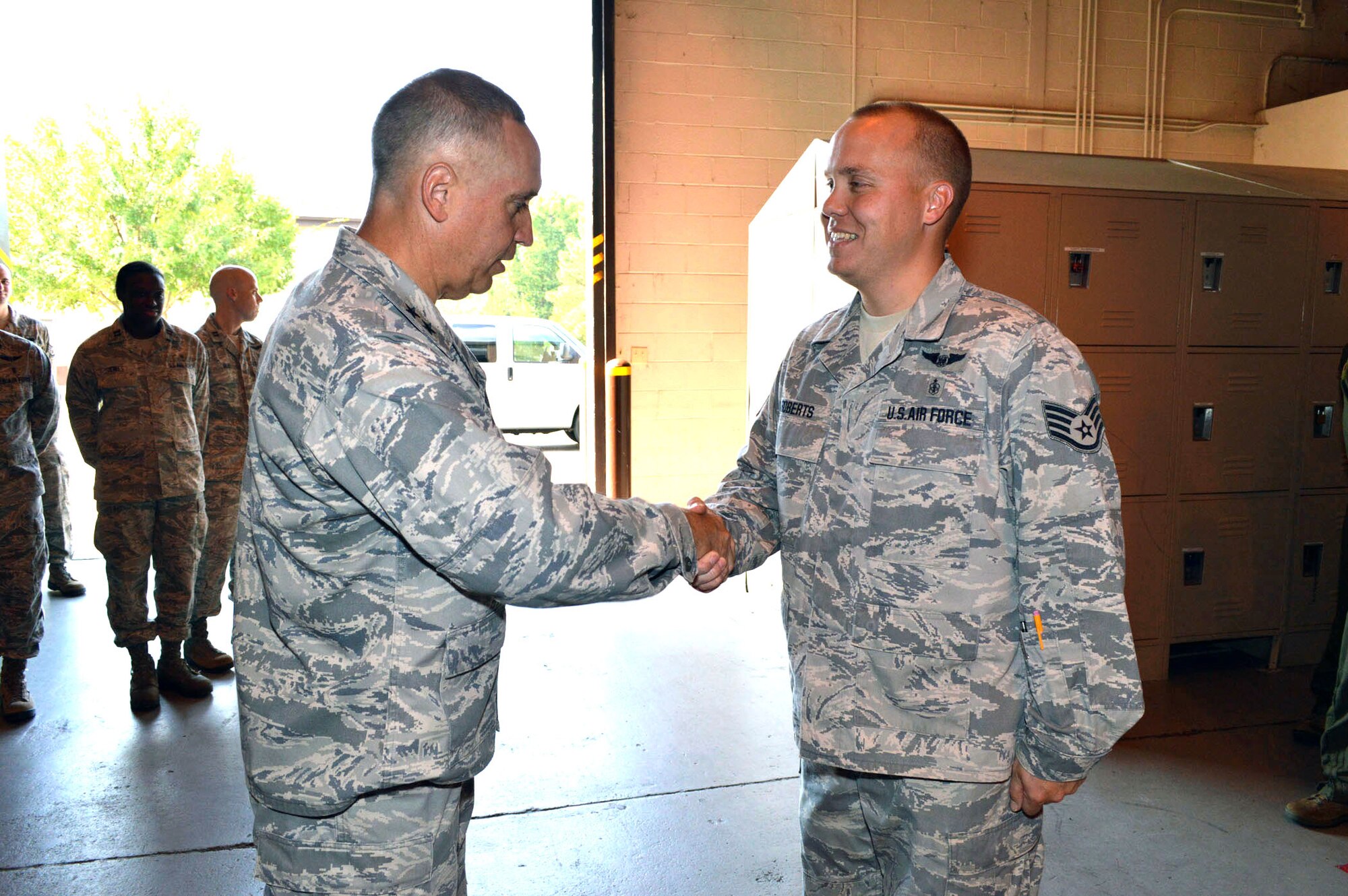 Maj. Gen. Rick Martin, U.S. Air Force Expeditionary Center commander, presents Staff Sgt. Patrick Roberts, 43d Aeromedical Evacuation Squadron, with his coin during his tour of 43d Airlift Group units Sep 16.  Sergeant Roberts meticulously coordinated nine Air Mobility Command aeromedical evacuation channel missions in Pacific Command’s area of responsibility, including the scheduling of 32 aircrew members, resulting in the safe airlift of 140 patients to definitive care at multiple United States and overseas medical treatment facilities.  General Martin visited Pope Army Airfield, N.C. to see first-hand how the 43d Airlift Group Airmen support the Global Response Force mission.  (U.S. Air Force Photo/Marvin Krause)