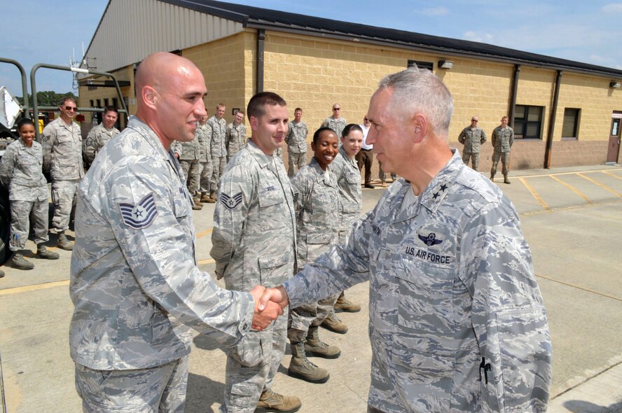 Maj. Gen. Rick Martin, U.S. Air Force Expeditionary Center commander, presents Tech. Sgt. Patrick Raible, 3d Aerial Port Squadron, with his coin after receiving a mission briefing about the 3d Aerial Port Squadron, during his tour of 43d Airlift Group units Sep 16.  Sergeant Raible overcame Air Force and Army communication challenges in order to establish the Global Air Transportation Execution System connectivity in the passenger sheds.  This initiative ended an 8-year in-transit visibility issue and reduced passenger processing time by 80 percent.  (U.S. Air Force Photo/Marvin Krause)