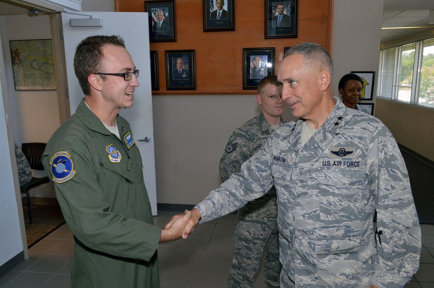 Maj. Gen. Rick Martin, U.S. Air Force Expeditionary Center commander, presents Tech. Sgt. Matthew Calhoun, 43d Operations Support Squadron, with his coin during his tour of 43d Airlift Group units Sep 16.  Sergeant Calhoun provides outstanding leadership for one third of the squadron’s manpower and maintains record of 99 percent error-free joint airdrop inspections for 30 percent of Air Mobility Command’s annual Joint Airborne and Air Transportability Training workload.  General Martin visited Pope Army Airfield, N.C. to see first-hand how the 43d Airlift Group Airmen support the Global Response Force mission.  (U.S. Air Force Photo/Marvin Krause)
