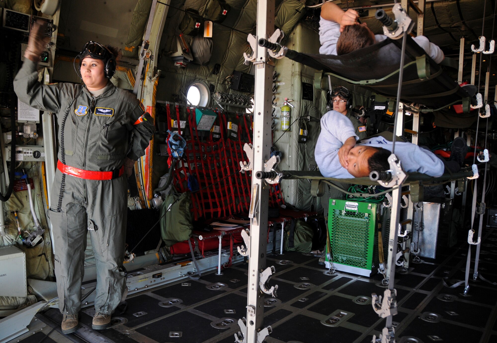 Senior Airman Kathleen Schrader with the 133rd Airlift Wing, guides Airmen and patients onto a C-130 during the Aeromedical Evacuation Flight from Duluth, Minnesota to the Twin Cities. The exercise simulated a terrorist incident in Duluth that resulted in civilian evacuations to the Twin Cities and Camp Ripley. The training partnered with 14 civilian agencies and utilized many of the 133AW capabilities to help both Airmen and civilians react better when facing disasters. (U.S. Air National Guard photo by Senior Airman Kari Giles.)