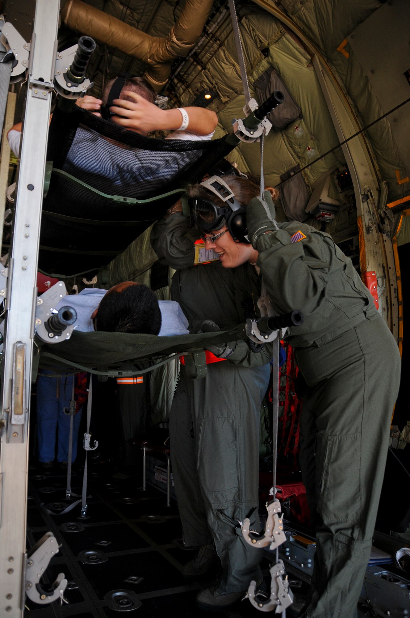 1st Lt. Theresa Stockton with the 133rd Airlift Wing, checks on a patient, while on the Aeromedical Evacuation Flight from Duluth, Minnesota to the Twin Cities. The exercise simulated a terrorist incident in Duluth that resulted in civilian evacuations to the Twin Cities and Camp Ripley. The training partnered with 14 civilian agencies and utilized many of the 133AW capabilities to help both Airmen and civilians react better when facing disasters. (U.S. Air National Guard photo by Senior Airman Kari Giles.)