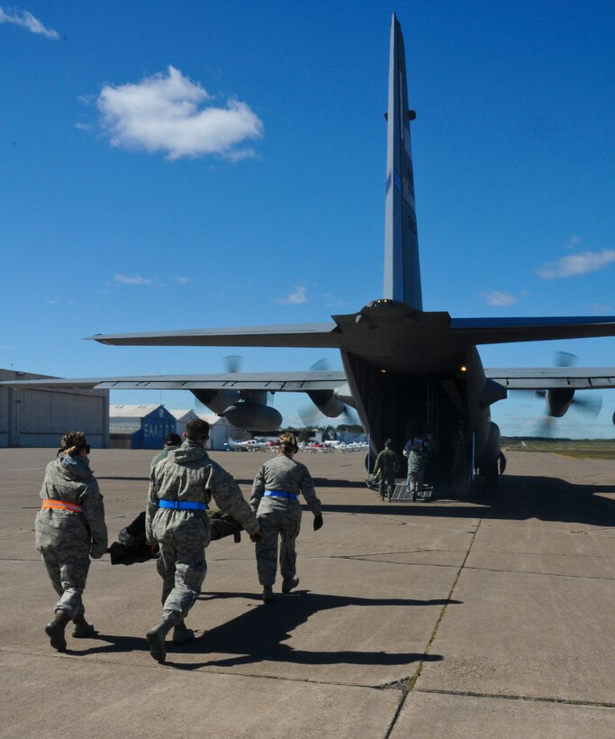 Airmen from the 133rd Airlift Wing, transports a patient to the C-130 as part of an Aeromedical Evacuation Flight from Duluth, Minnesota to the Twin Cities. The exercise simulated a terrorist incident in Duluth that resulted in civilian evacuations to the Twin Cities and Camp Ripley. The training partnered with 14 civilian agencies and utilized many of the 133AW capabilities to help both Airmen and civilians react better when facing disasters. (U.S. Air National Guard photo by Senior Airman Kari Giles.)