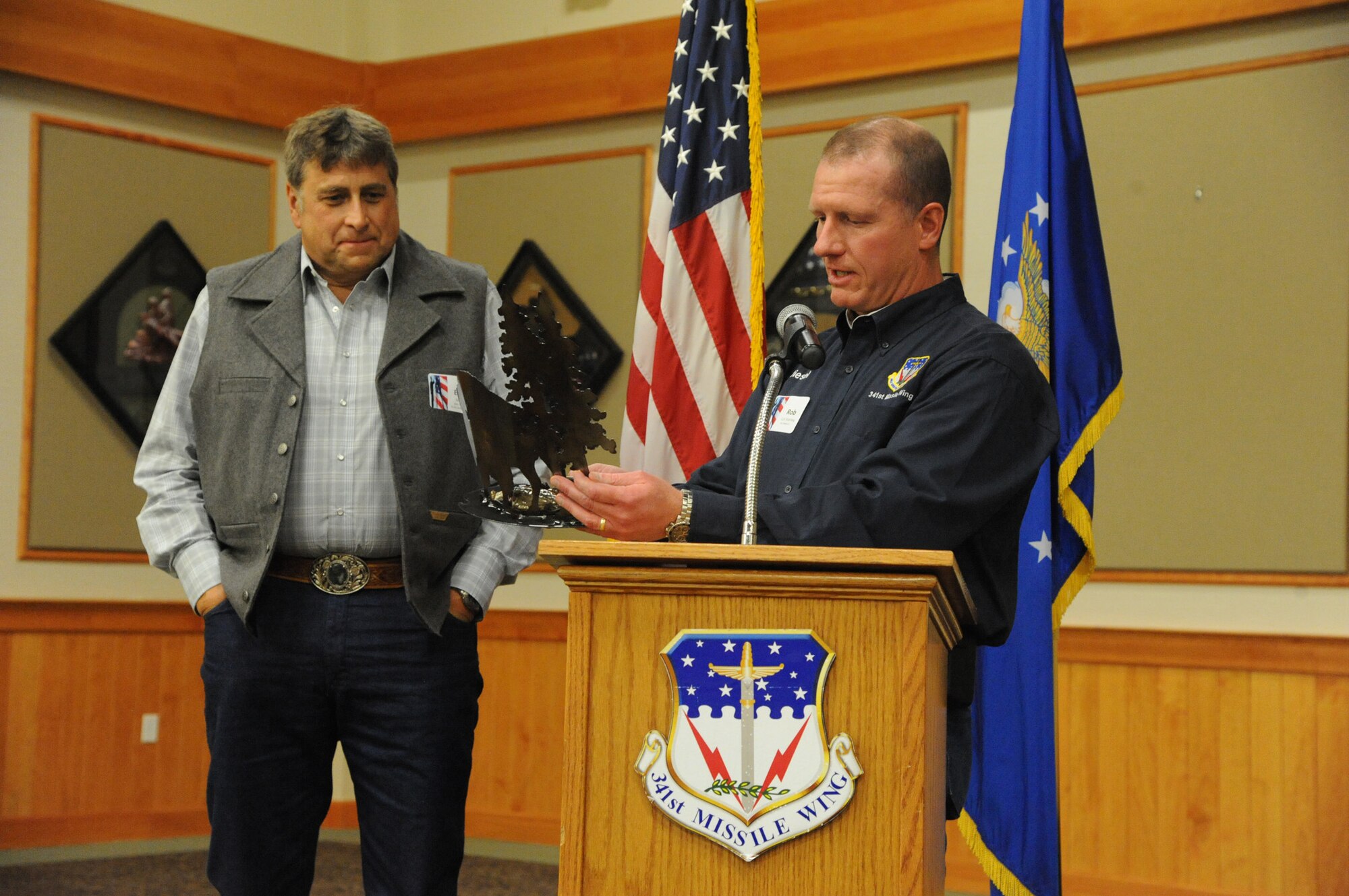 Col. Robert Stanley, 341st Missile Wing commander, (right) reads the plaque of an award before presenting it to Erling Juel for his commitment to Malmstrom Air Force Base as the Military Affairs Committee Chairman during a Salute to the Community Dinner at the Grizzly Bend on Sept. 21.  The dinner was a way for Malmstrom leadership to thank members of the surrounding communities for their support.  (U.S. Air Force photo/Senior Airman Cortney Paxton)