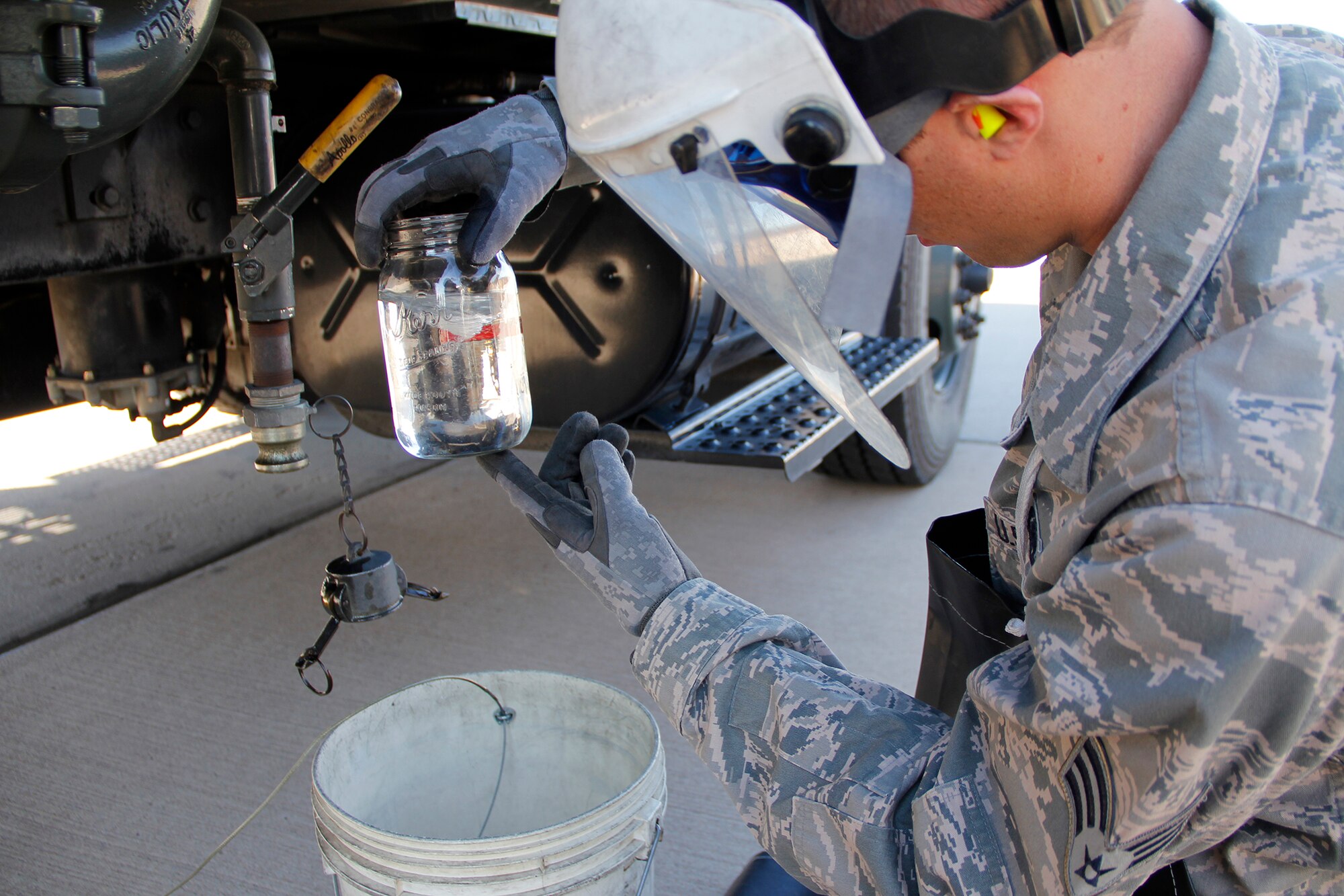 Senior Airman Daniel Hirsch, 302nd Logistics Readiness Squadron fuel technician, takes a sample of JP-8 jet fuel from the filter separator on the R-11 fuel truck to check the fuel for contaminants. (U.S. Air Force photo/Staff Sgt. Nathan Federico)
