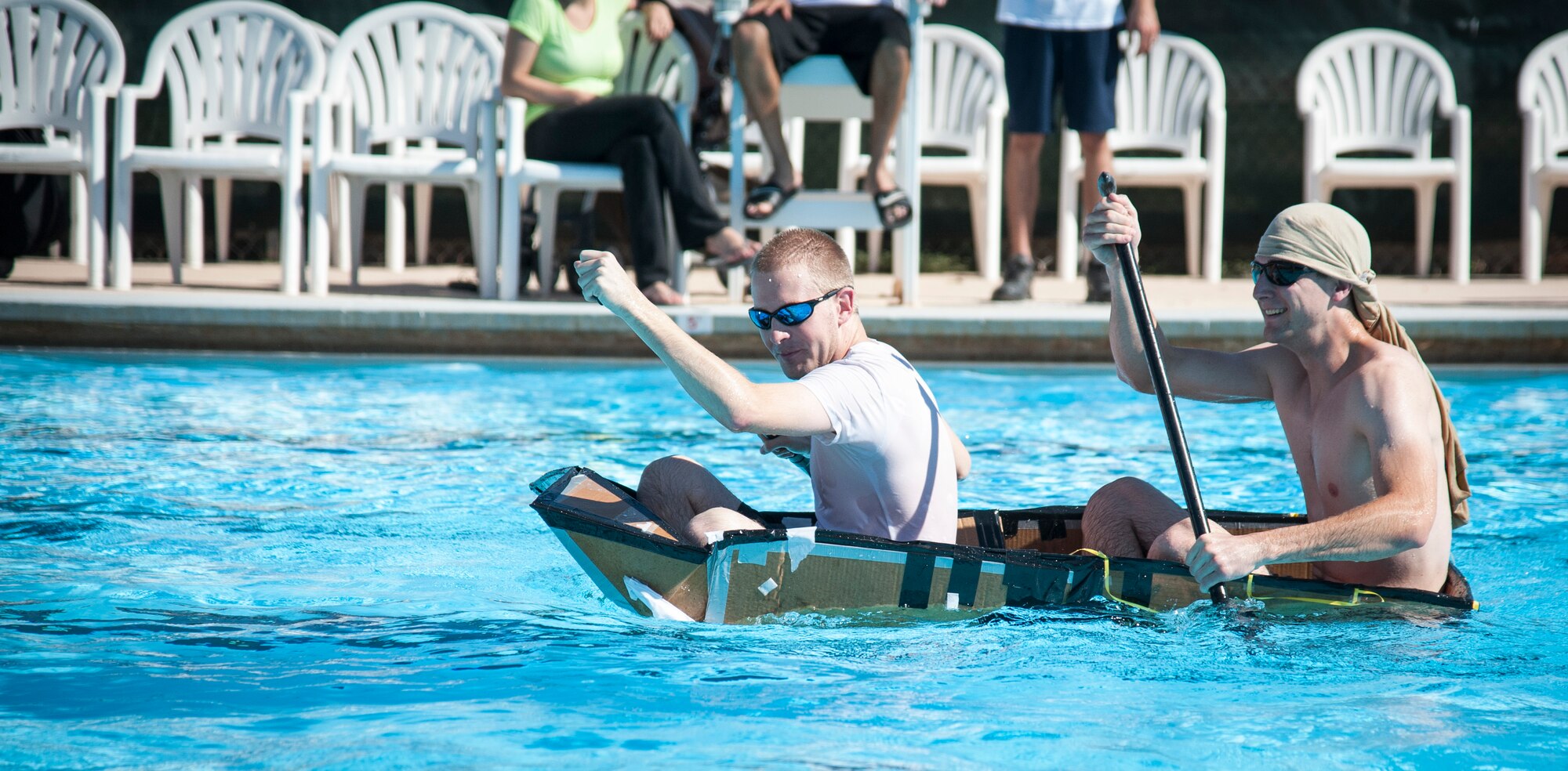 Brad Clawson, left, and 2nd Lt. Charles Heim, both from the 47th Civil Engineer Squadron, paddle towards the finish line at Laughlin’s Friendship Pool Sept. 25, 2013. Their boat filled with water on their first attempt, but upon their reentry into the water, they were one of the few that made it across the pool. (U.S. Air Force photo/Senior Airman John D. Partlow)