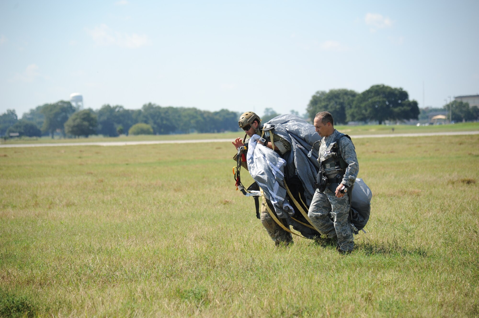 Master Sgt. Wesley Bonin, 403rd Wing, and Col. George Tombe, 81st Training Group commander, walk across the flight line after completing a tandem jump Sept. 25, 2013, over Keesler Air Force Base, Miss.  Tombe jumped in conjunction with the 334th Training Squadron combat controllers and the 335th Training Squadron special operations weather team for training.  (U.S. Air Force photo by Kemberly Groue)