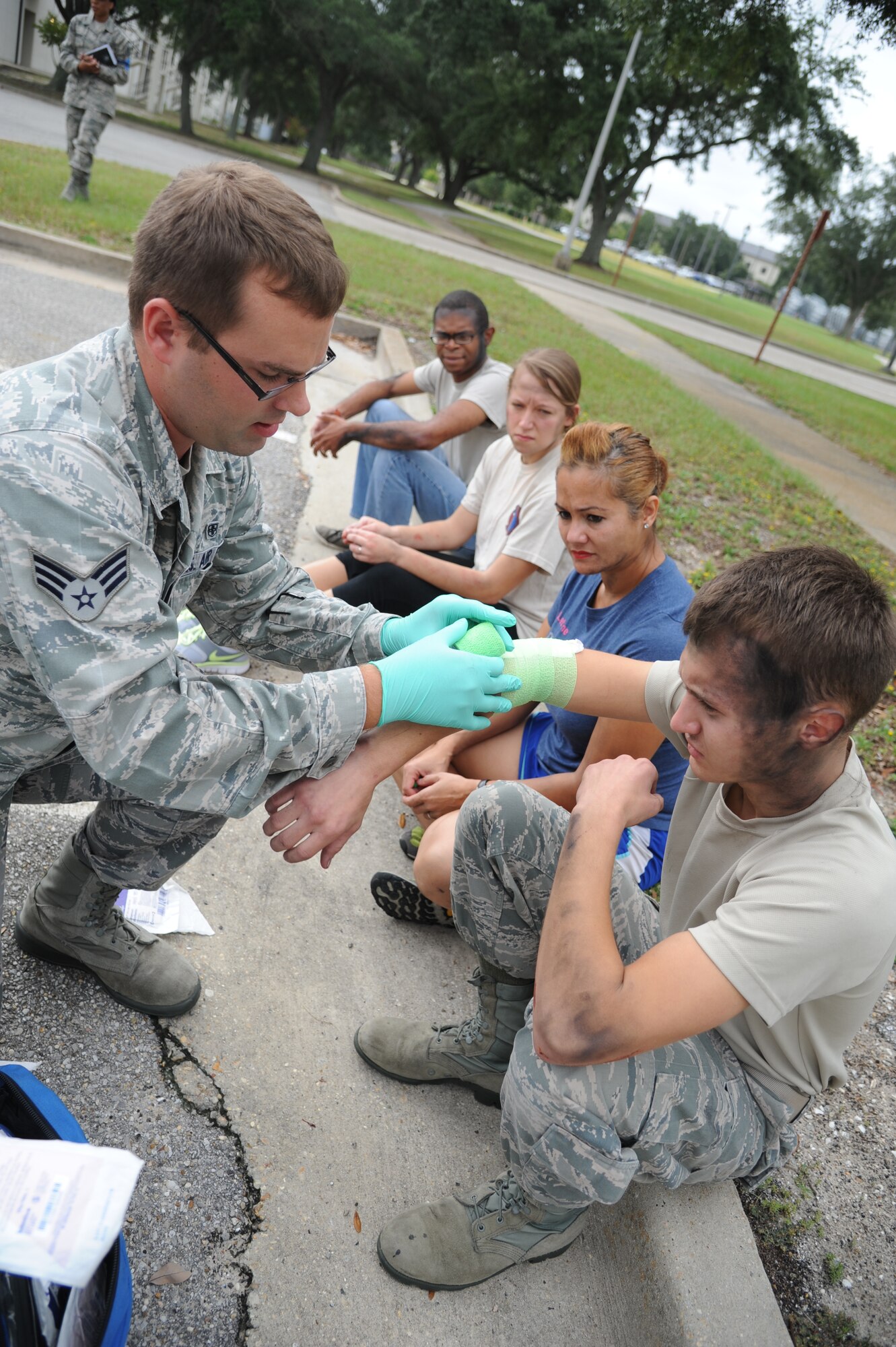 Senior Airman Andy Davenport, 81st Medical Operations Squadron, administers care to Airman 1st Class Austen Koczent, 81st Medical Operations Squadron, during a structure fire exercise Sept. 25, 2013, Keesler Air Force Base, Miss.  The scenario consisted of a simulated explosion in a boiler room causing a fire to spread rapidly throughout the building trapping and injuring five role players.  (U.S. Air Force photo by Kemberly Groue)