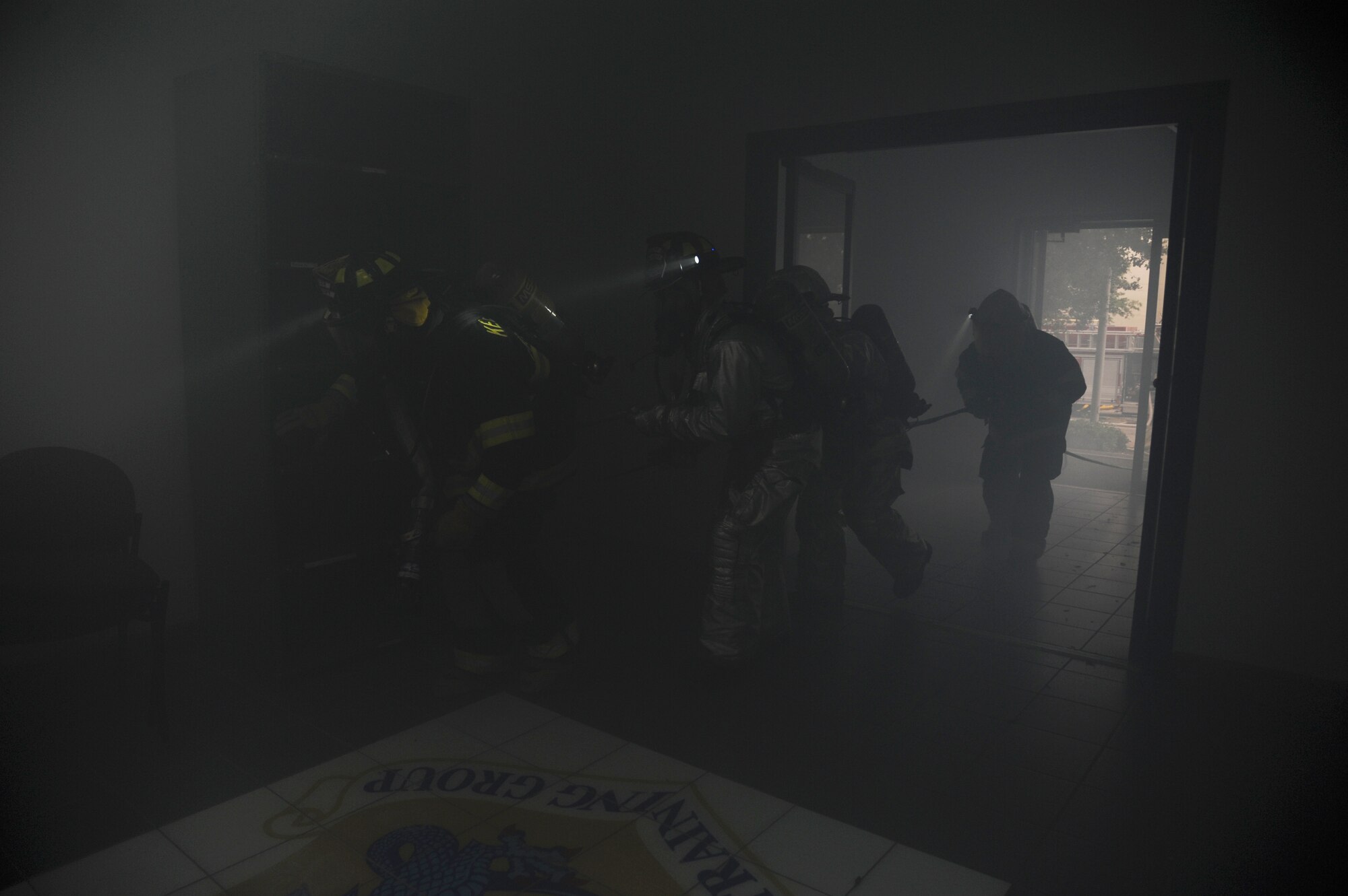 Members of the Keesler Fire Department enter a building during a structure fire exercise Sept. 25, 2013, Keesler Air Force Base, Miss. The scenario consisted of a simulated explosion in a boiler room causing a fire to spread rapidly throughout the building trapping and injuring five role players.  (U.S. Air Force photo by Kemberly Groue)