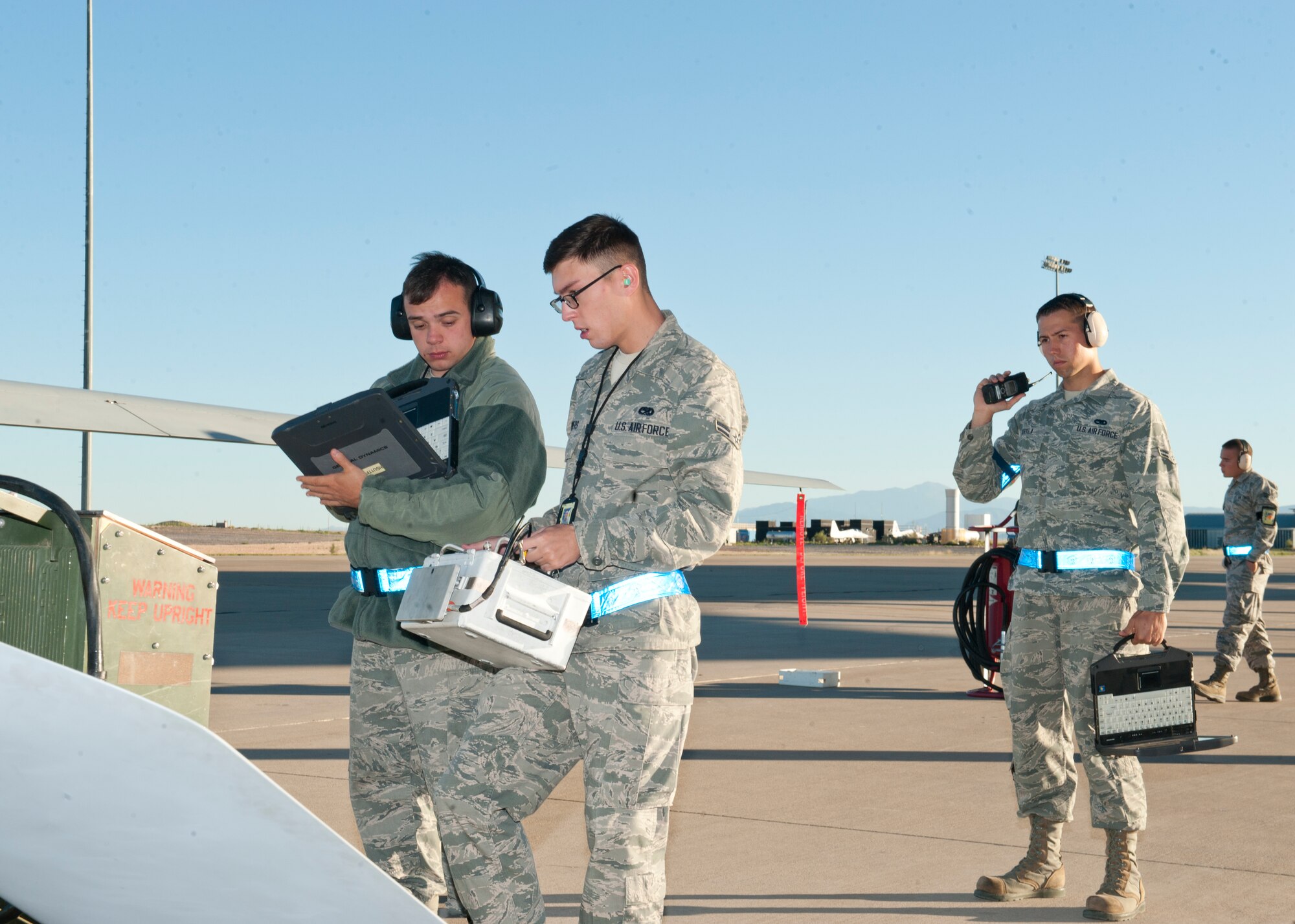 Airman 1st Class Ryan Noonan and Airman 1st Class Jacob Powers, both 849th Aircraft Maintenance Squadron avionics specialists perform maintenance checks on the MQ-1 Predator as Airman 1st Class Justin Kryla, 849th Aircraft Maintenance Squadron crew chief, communicates with the aircrew at Holloman Air Force Base, N.M., Sept. 25. The Predator’s primary functions are to fulfill reconnaissance and forward observation roles.  In addition to the pilot and sensor operator who control the aircraft from a ground control station, flying an MQ-1 requires a culmination of efforts from various squadrons. (U.S. Air Force photo by Airman 1st Class Daniel E. Liddicoet/Released)