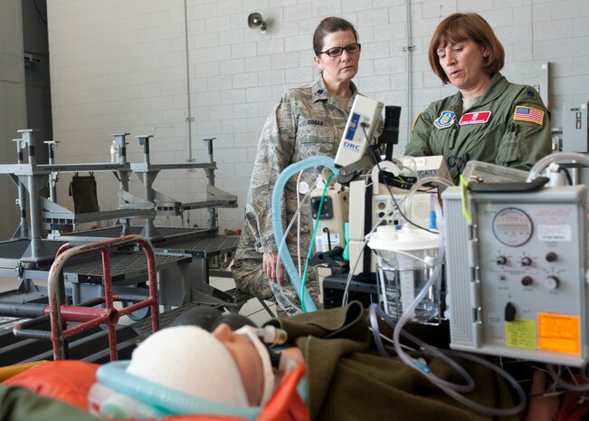 Lt. Col. (Dr.) Allison Cogar, 99th Surgical Operations Squadron, and Lt. Col. (Dr.) Liane Weinberger, 302nd Airlift Wing at Peterson Air Force Base, Colo., assess a simulated patient Sept. 19, 2013, during a Federal Coordination Center Exercise at the medical reception hangar at Nellis Air Force Base, Nev. A C-130 Hercules from the 302nd AW brought simulated patients to participate in the exercise. (U.S. Air Force photo by Staff Sgt. Michael Charles)