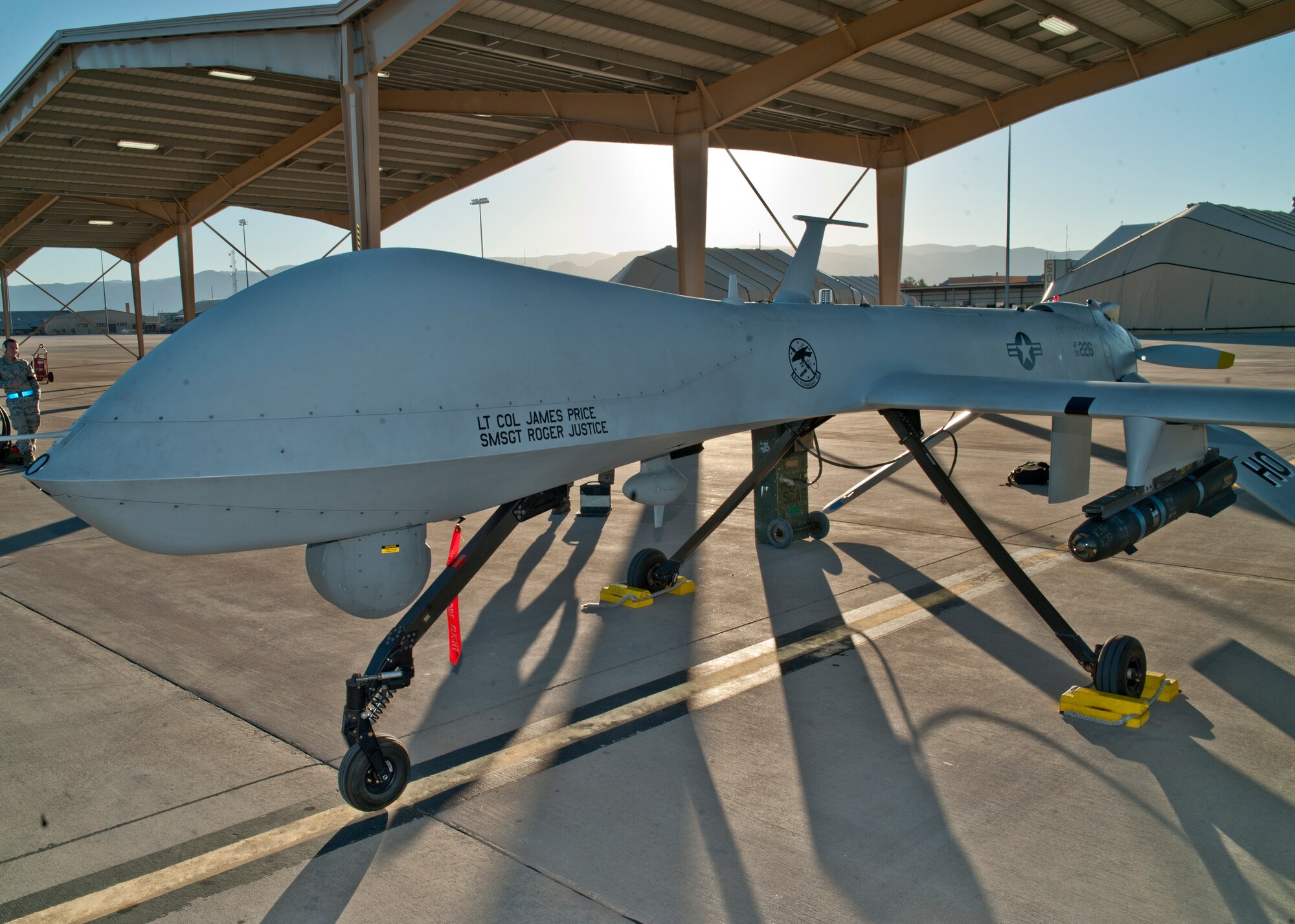 An MQ-1 Predator is docked under a sun shade as it is prepared for take-off at Holloman Air Force Base, N.M., Sept. 25.  The Predator’s primary functions are to fulfill reconnaissance and forward observation roles.  In addition to the pilot and sensor operator who control the aircraft from a ground control station, flying an MQ-1 requires a culmination of efforts from various squadrons. (U.S. Air Force photo by Airman 1st Class Daniel E. Liddicoet/Released)