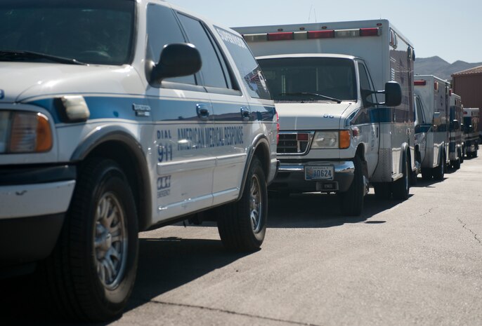 Ambulances and emergency response vehicles line up in front of the 823rd Maintenance Squadron Sept. 19, 2013, during Operation Swift Savior, a National Disaster Medical Services exercise, at Nellis Air Force Base, Nev.  The 823rd MXS acted as the staging point for a simulated incoming patients and reception area for mission essential non-base employees assisting with the treatment and transportation of simulated patients from a VA hospital in Phoenix evacuated to local Southern Nevada hospitals. (U.S. Air Force photo by Staff Sgt. Michael Charles)