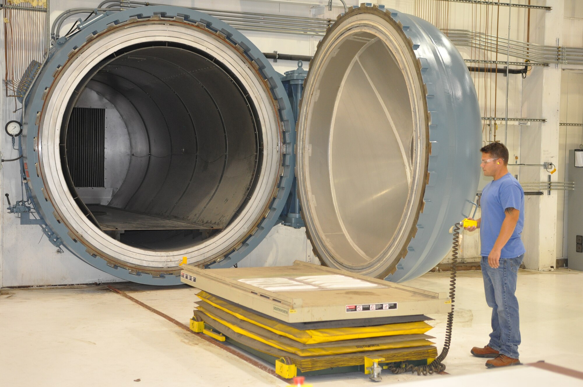 Jason Ford, 551st Commodities Maintenance Squadron aircraft mechanic, raises a KC-135 Stratotanker elevator skin panel to put in the autoclave for metal-to-metal bonding. Similar to an oven baking cookies, the autoclave cures composites under nitrogen pressure and electric heat. Autoclaves are energy hogs and to help keep costs down, workers monitor their usage but are careful not to impact production. (Air Force photo by Brandice J. O’Brien)