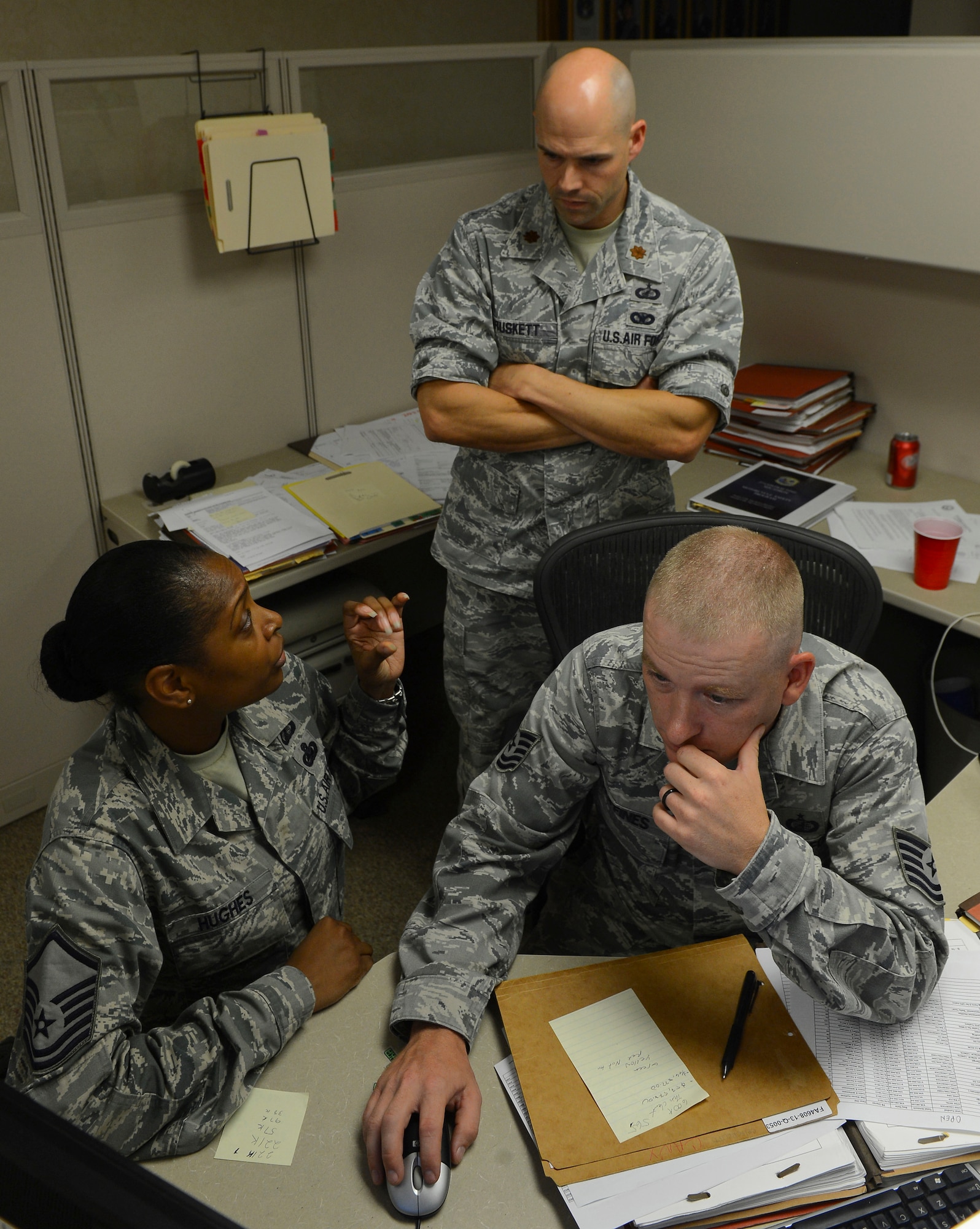 Master Sgt. Tonya Hughes, left, Maj. Garrett Truskett and Tech. Sgt. Steven Huffines, 2nd Contracting Squadron, flight chief, commander and contracting officer, respectively talk about purchase lists requests on Barksdale Air Force Base, La., Sept. 20, 2013. The Airmen met to determine which contracts were going to be spent for the end of fiscal year soft closeout. (U.S. Air Force photo\Senior Airman Micaiah Anthony)
