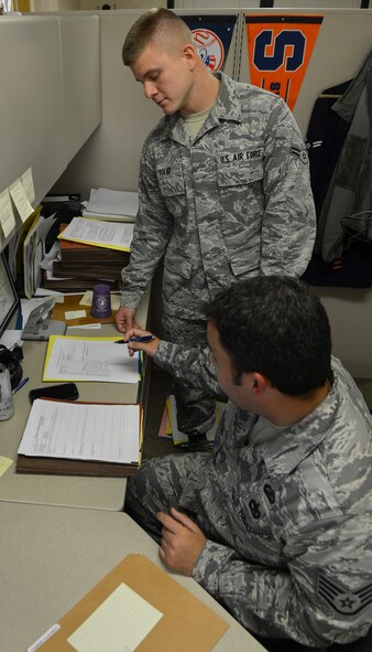 Staff Sgt. Justin Williamson talks with Airman 1st Class Kristopher Tolar, 2nd Contracting Squadron contracting specialists, about a contract on Barksdale Air Force Base, La., Sept. 20, 2013. Contracting specialists conduct market research with various companies to acquire the best deals for the base and ensure proper protocol is followed when securing contracts for services. (U.S. Air Force photo\Senior Airman Micaiah Anthony)