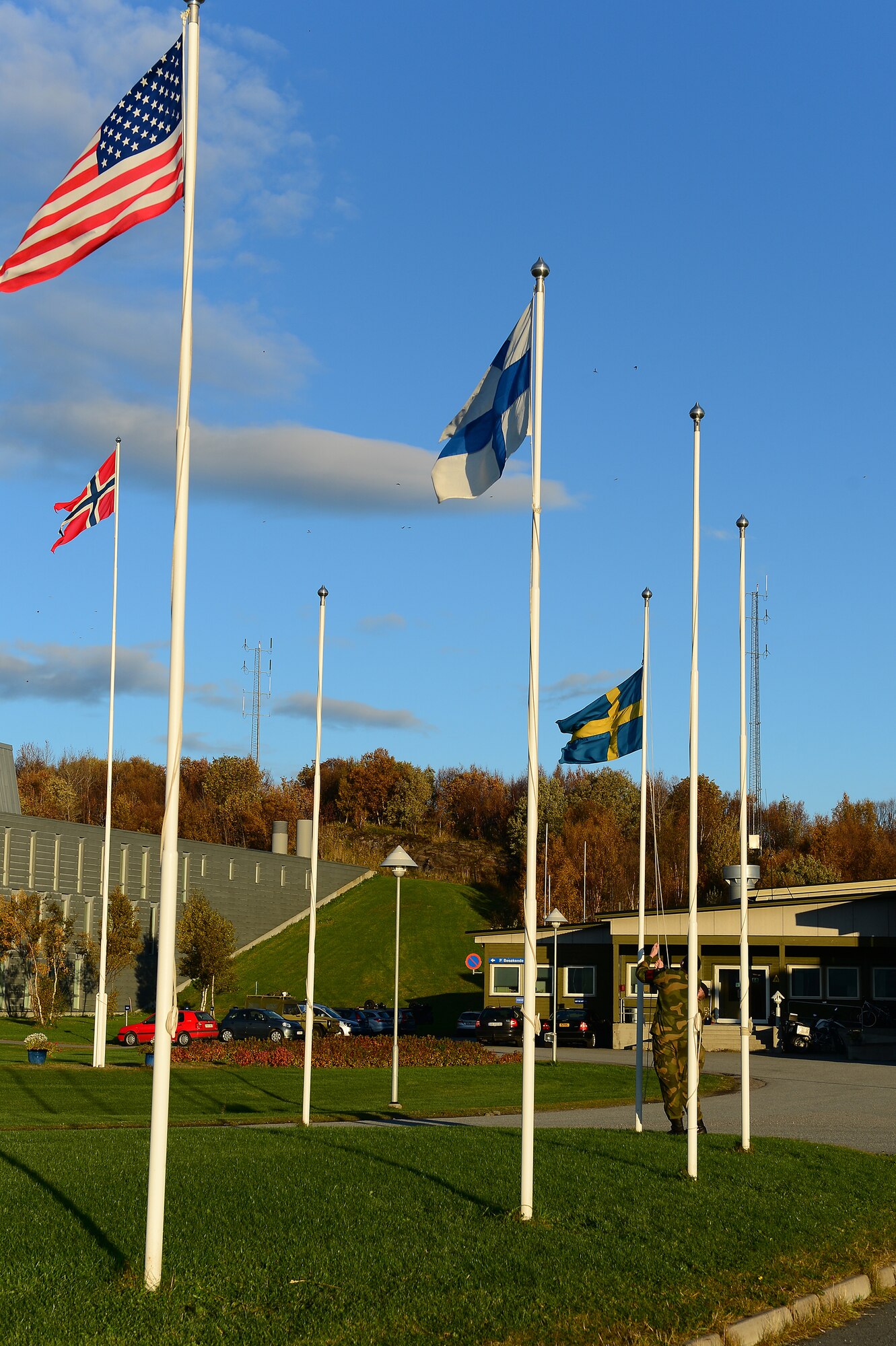 Royal Norwegian Air Force members raise the flags on Bodø Main Air Station, Norway, Sept. 24, 2013. Approximately 600 personnel deployed from multiple bases within U.S. Air Forces in Europe-Air Forces Africa in support of the Arctic Challenge Exercise 2013. ACE-13 is a combined exercise with NATO and regional allies which promotes continued interoperability between the United States, Norway, Sweden, Finland, United Kingdom and NATO. (U.S. Air Force photo by Master Sgt. Lee Osberry/Released)