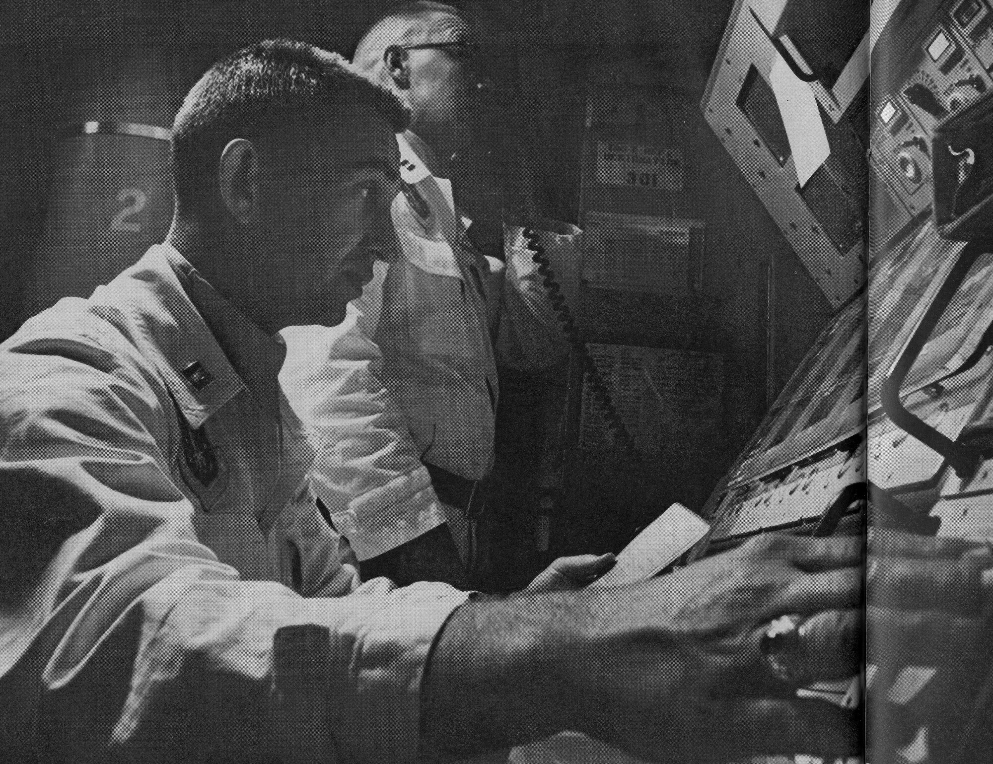 In this photo from November 1964, Captains Allen Lamb and Bill Christians, communicate with members of their squadron while on duty at a launch control center. The 91st Missile Wing completed a Simulated Electronic Launch - Minuteman, or SELM, operational test, Sept. 17 to 18. SELM verifies the procedures in the launch control center, ensuring that the missile launch officers are proficient in executing their mission. (LIFE photo/Bill Ray)