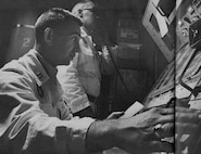 In this photo from November 1964, Captains Allen Lamb and Bill Christians, communicate with members of their squadron while on duty at a launch control center. The 91st Missile Wing completed a Simulated Electronic Launch - Minuteman, or SELM, operational test, Sept. 17 to 18. SELM verifies the procedures in the launch control center, ensuring that the missile launch officers are proficient in executing their mission. (LIFE photo/Bill Ray)