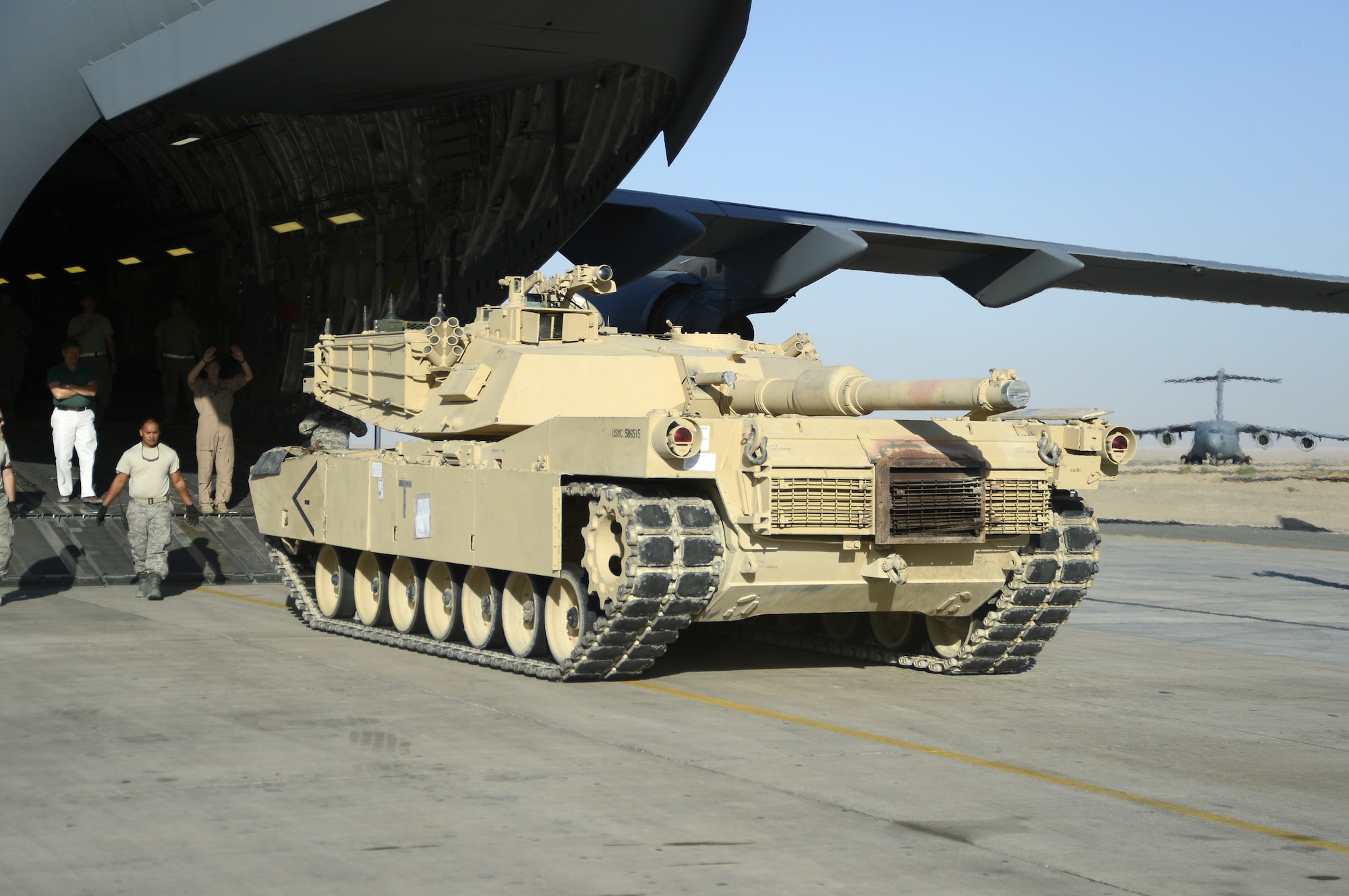 Members of the 386th Air Expeditionary Wing monitor the offload of a M1 Abrams tank from a C-17 Globemaster III here, Sept. 26, 2013.  The M1 tank offload took little time because of the communication and cooperation of the flight crew, 386th Expeditionary Logistics Readiness Squadron personnel, airfield management and the tank driver. (U.S. Air Force photo by Master Sgt. Christopher A. Campbell)