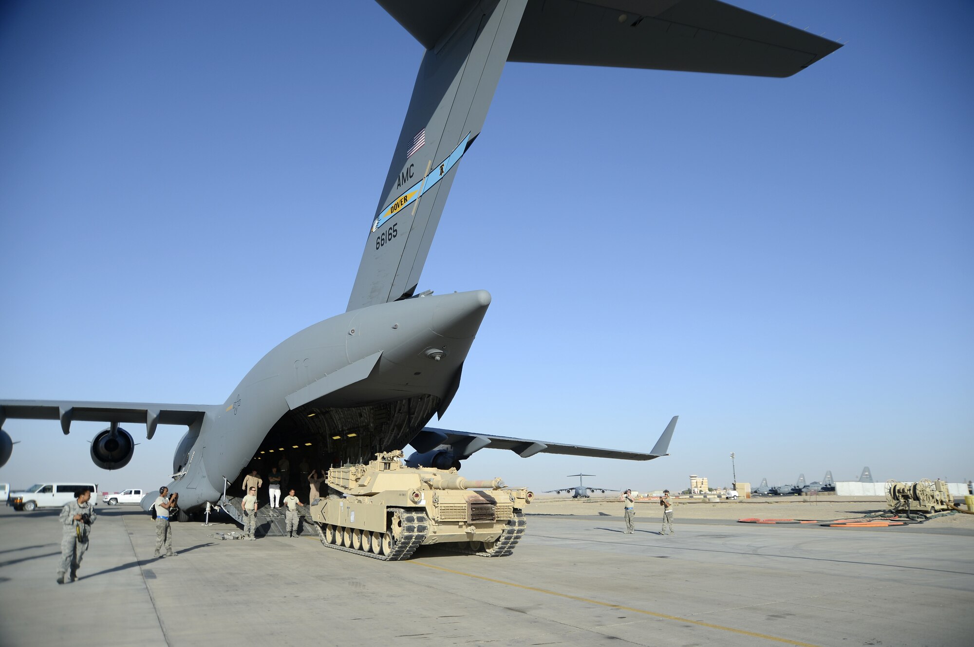 Members of the 386th Air Expeditionary Wing monitor the offload of a M1 Abrams tank from a C-17 Globemaster III here, Sept. 26, 2013.  The M1 tank offload took little time because of the communication and cooperation of the flight crew, 386th Expeditionary Logistics Readiness Squadron personnel, airfield management and the tank driver. (U.S. Air Force photo by Master Sgt. Christopher A. Campbell)