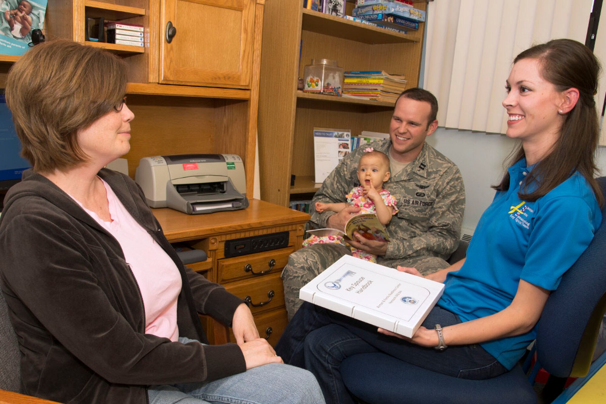 HANSCOM AIR FORCE BASE, Mass. – New Key Spouse Jade Wilson (right), speaks with Kristina Marsh (left), whose husband Lt. Col. David Marsh is currently deployed, during a Hearts Apart event at the Airman and Family Readiness Center Sept. 25 as Capt. Jonathan Wilson and their daughter Riley look on. Inspired by the support she received while her husband was deployed; Wilson recently became a Key Spouse. Wilson and 10 other volunteers make sure they establish and maintain contact with families of deployed members, provide information and referral to base and community resources and promote individual, family and unit readiness (U.S. Air Force photo by Walter Santos)