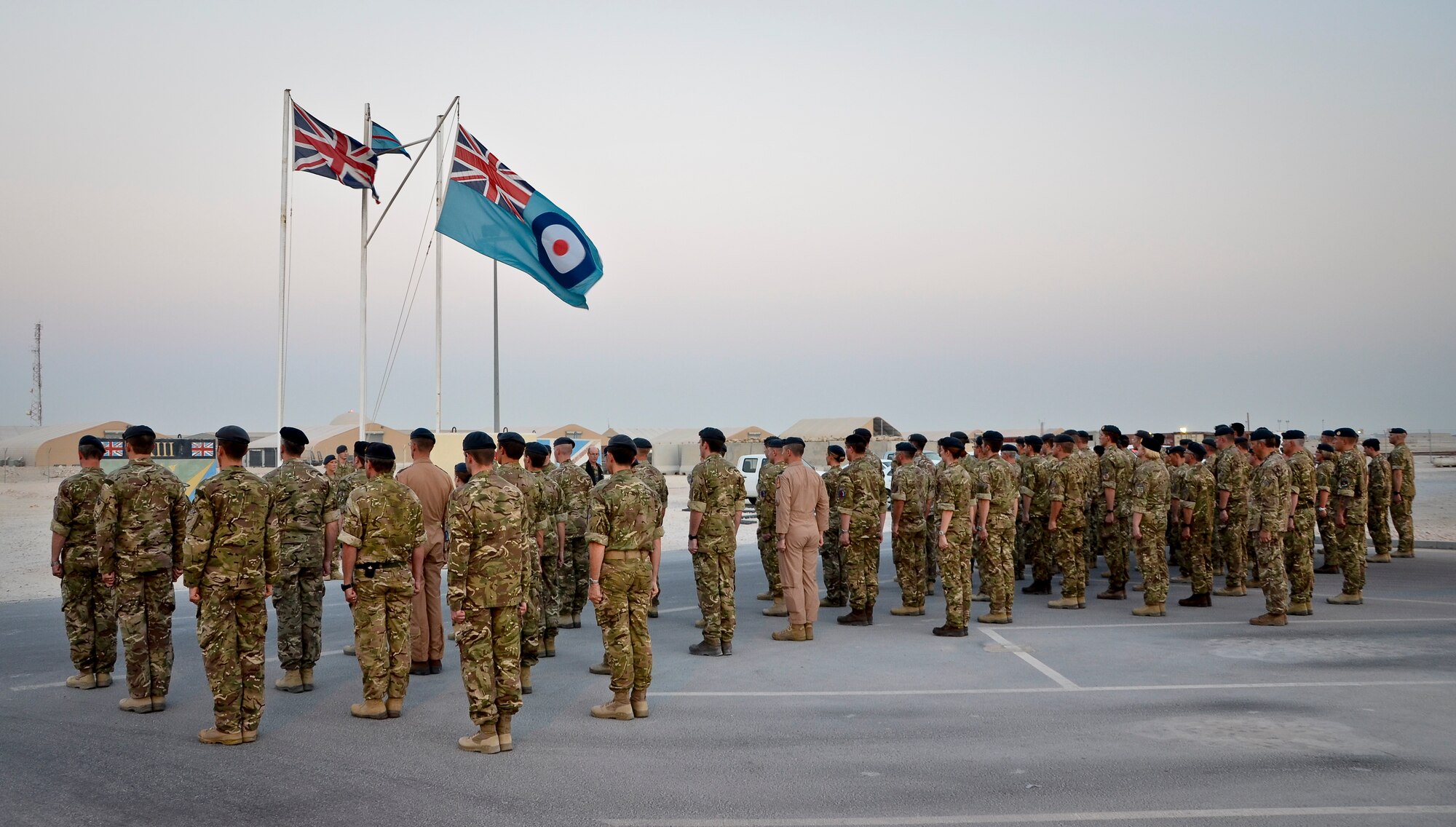 Royal Air Force service members respectfully stand at attention as Capt. Haley Armstrong plays “Last Post” and “Reveille” on her trumpet during the Battle of Britain Day parade ceremony at the 379th Air Expeditionary Wing in Southwest Asia, Sept. 20, 2013. The RAF holds this day special as it was the day the Luftwaffe embarked on their largest bombing attack yet, forcing the engagement of the entire RAF Fighter Command in defense of London and the South East, which resulted in a decisive victory in favor of Britain and marked a turning point in the war. Armstrong is the U.S. Air Forces Central Command band officer in charge deployed from Yokota Air Base, Japan, and hails from Sonora, Calif. (U.S. Air Force photo/Staff Sgt. Benjamin W. Stratton)