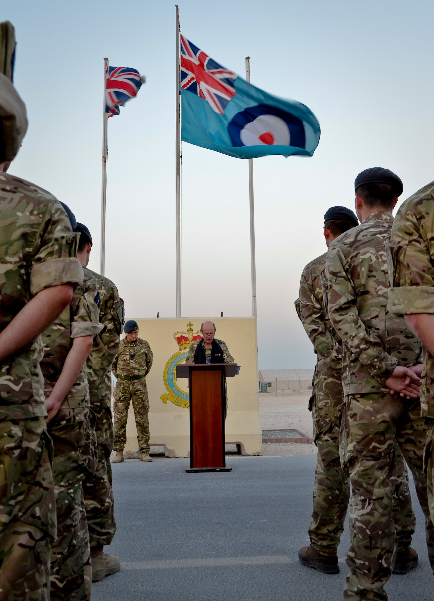 Royal Air Force service members bow their heads as Reverend (Sqdn. Leader) Andrew Wakeham-Dawson leads the group in prayer during the Battle of Britain Day parade ceremony at the 379th Air Expeditionary Wing in Southwest Asia, Sept. 20, 2013. The RAF holds this day special as it was the day the Luftwaffe embarked on their largest bombing attack yet, forcing the engagement of the entire RAF Fighter Command in defense of London and the South East, which resulted in a decisive victory in favor of Britain and marked a turning point in the war. (U.S. Air Force photo/Staff Sgt. Benjamin W. Stratton)