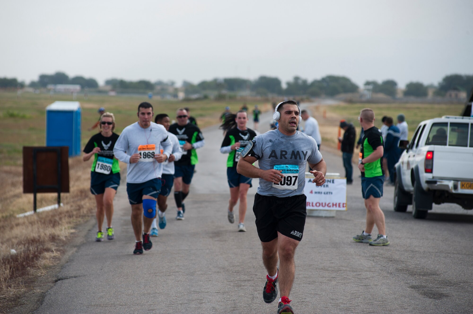 Competing Air Force and Army members pass a water station during the Air Force Marathon at Transit Center at Manas, Kyrgyzstan, Sept. 21, 2013. There were eight water stations positioned along the marathon course to ensure safety, health and morale. (U.S. Air Force photo/Staff Sgt. Robert Barnett)