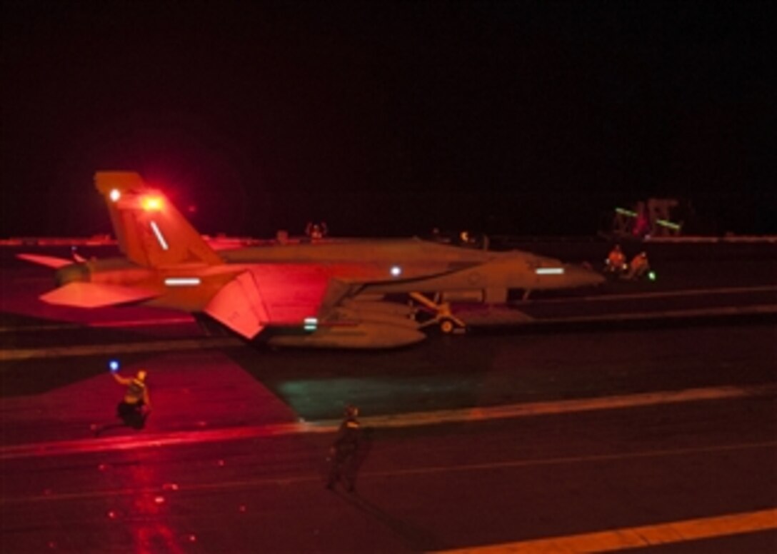 A U.S. Navy F/A-18F Super Hornet is prepared for a nighttime catapult launch from the aircraft carrier USS George Washington (CVN 73) as the ship conducts flight operations in the Philippine Sea on Sept. 26, 2013.  The George Washington and its embarked Carrier Air Wing 5 are deployed to conduct maritime security operations and theater security cooperation efforts in the Pacific.  The Super Hornet is attached to Strike Fighter Squadron 115.  