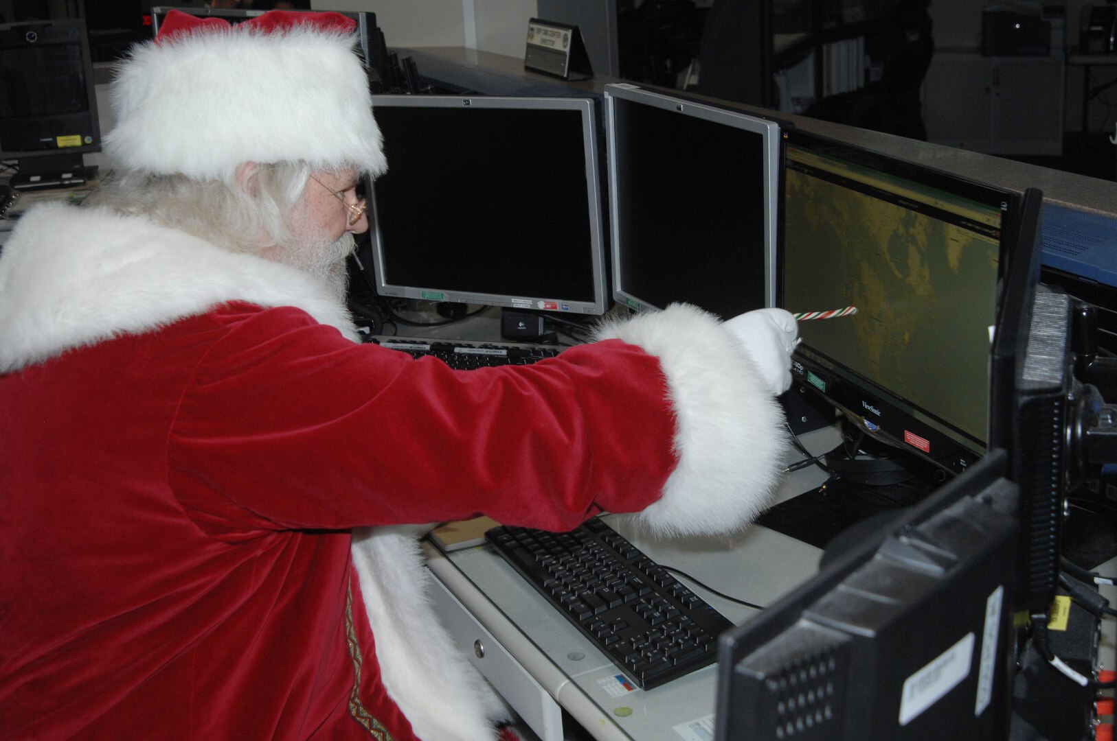 Santa Claus reviews his flight plan for his Dec. 25 trek across the globe in the North American Aerospace Defense Command and U.S. Northern Command Current Operations Center Thursday, Sept. 26, 2013, at the NORAD and USNORTHCOM headquarters at Peterson Air Force, Colo.  Santa’s visit today comes in advance of the commands' annual NORAD Tracks Santa outreach effort, which is expected to reach more than 20 million unique visitors on the www.noradsanta.org website.