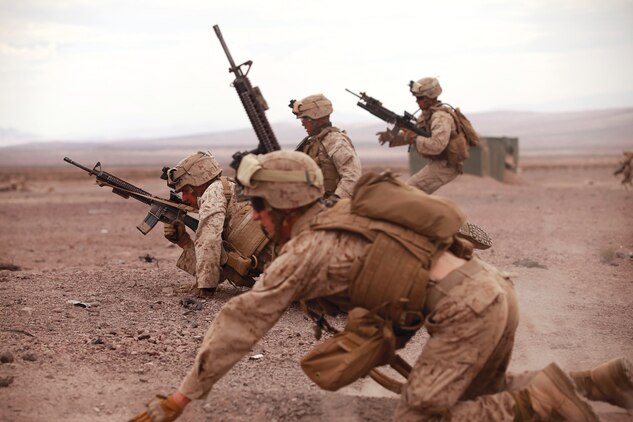 Marines with Golf Company, 2nd Battalion, 3rd Marine Regiment, assault an objective in the Quackenbush training area at the Marine Corps Air Ground Combat Center, Calif., during a company-sized mechanized assault course Sept. 9, 2013. The MAC was a company-level assault on three enemy objectives. Engineers cleared the area of simulated mines while infantrymen provided cover fire. Once the engineers provided a safe path, the infantrymen maneuvered toward the objective until it was overrun. (U.S. Marine Corps photo by Cpl. Sarah Dietz)