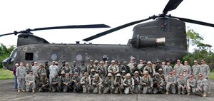 Members of Joint Task Force-Bravo and members of the Belizean armed forces pose in front of one of Joint Task Force-Bravo's CH-47 Chinook helicopter's prior to a training exercise in Belize, Sept. 26, 2013.  Joint Task Force-Bravo and the Belizean military performed joint military training in order to enhance operational capabilities as well as to continue to build international relationships.  (U.S. Air Force photo by Capt. Zach Anderson)