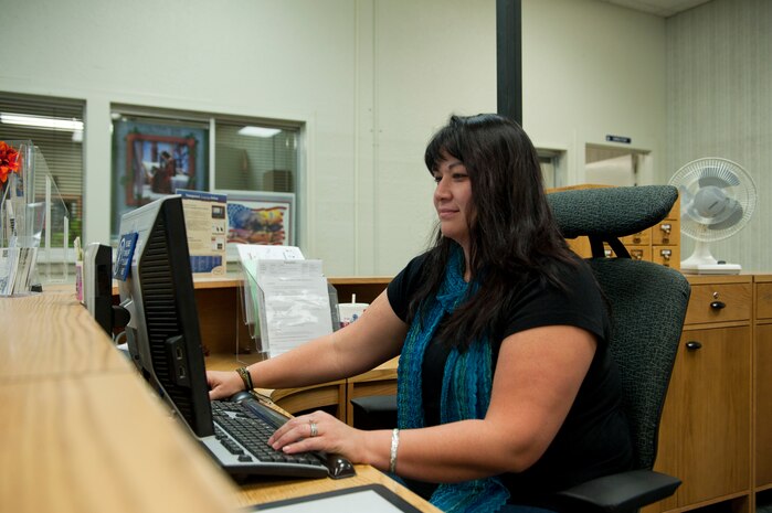 Natalie Johnson, 99th Force Support Squadron librarian, works at the library front desk Sept. 27, 2013, at Nellis Air Force Base, Nev. Air Combat Command eliminated the funding to maintain library services throughout the command for fiscal year 2014. Nellis AFB will suspend all library services effective Sept. 30, 2013. (U.S. Air Force photo by Airman 1st Class Thomas Spangler)