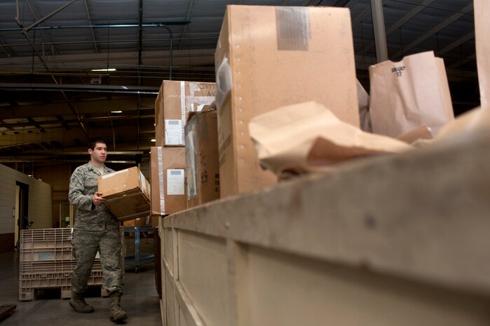 Senior Airman Donovan Ortiz, 99th Logistics Readiness Squadron outbound cargo traffic management journeyman, moves a package to a table to be inspected Sept. 27, 2013, at Nellis Air Force Base, Nev. Airmen who work with outbound cargo conduct an in-checking process to ensure cargo is properly prepared. In-checking consists of packing, processing, and moving cargo. (U.S. Air Force photo by Staff Sgt. Christopher Hubenthal)