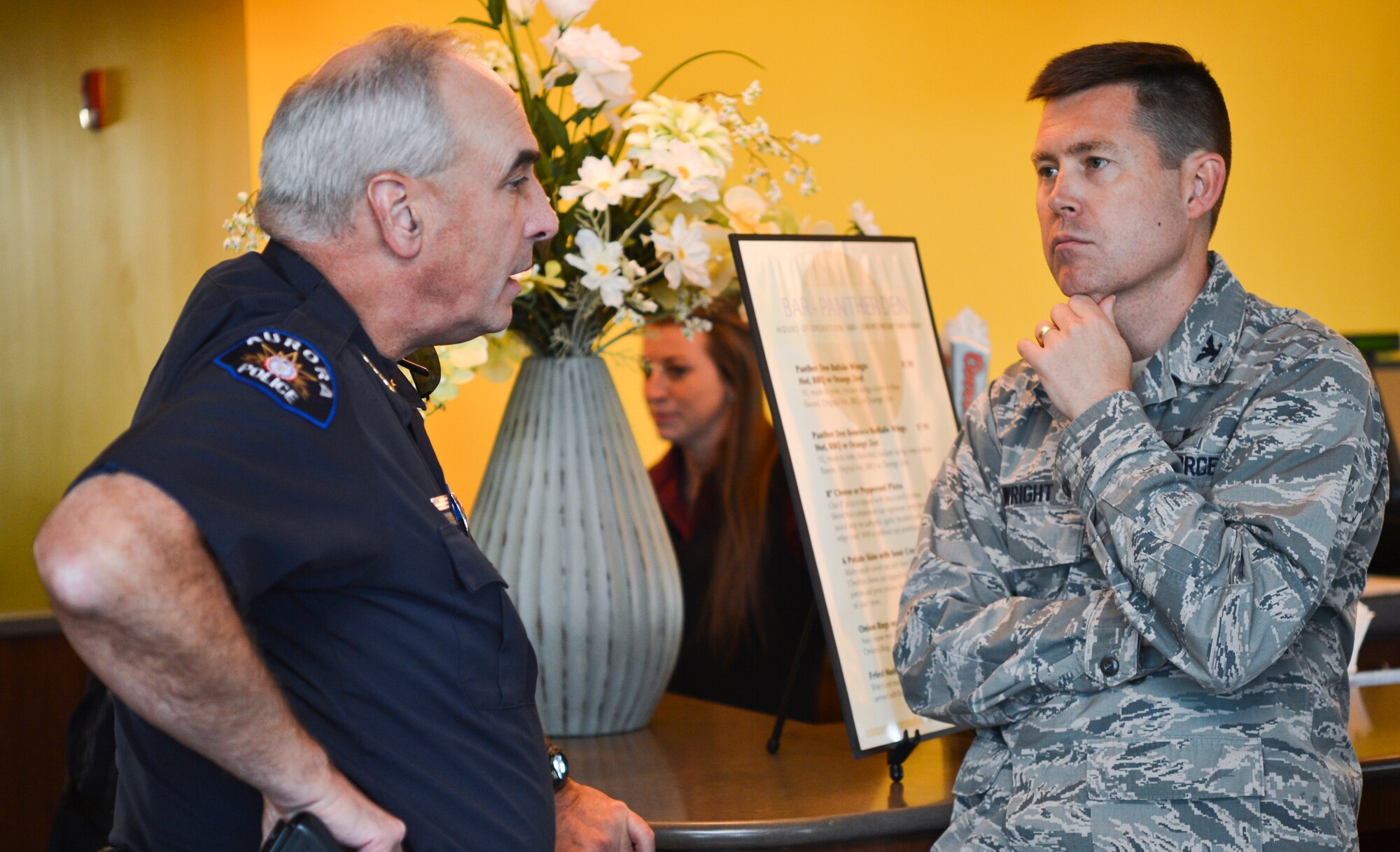 Police Chief Daniel Oates, Aurora Police Department, left, speaks with Col. Dan Wright, 460th Space Wing commander, Sept. 26, 2013, at the Panther’s Den during a community commanders program meeting at Buckley Air Force Base, Colo. The main objective of the Co-Commanders Program is to educate civilian community leaders by coupling them with Team Buckley senior leaders and informing them about the operations of the base. (U.S. Air Force photo by Staff Sgt. Paul Labbe/Released) 