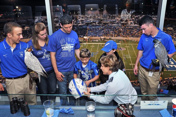 Academy Superintendent Lt. Gen. Michelle Johnson (right) gives Aubrey Aragon a Falcon football helmet, signed by the players, at the Air Force-Wyoming football game Sept. 21. (U.S. Air Force Photo/Liz Copan)