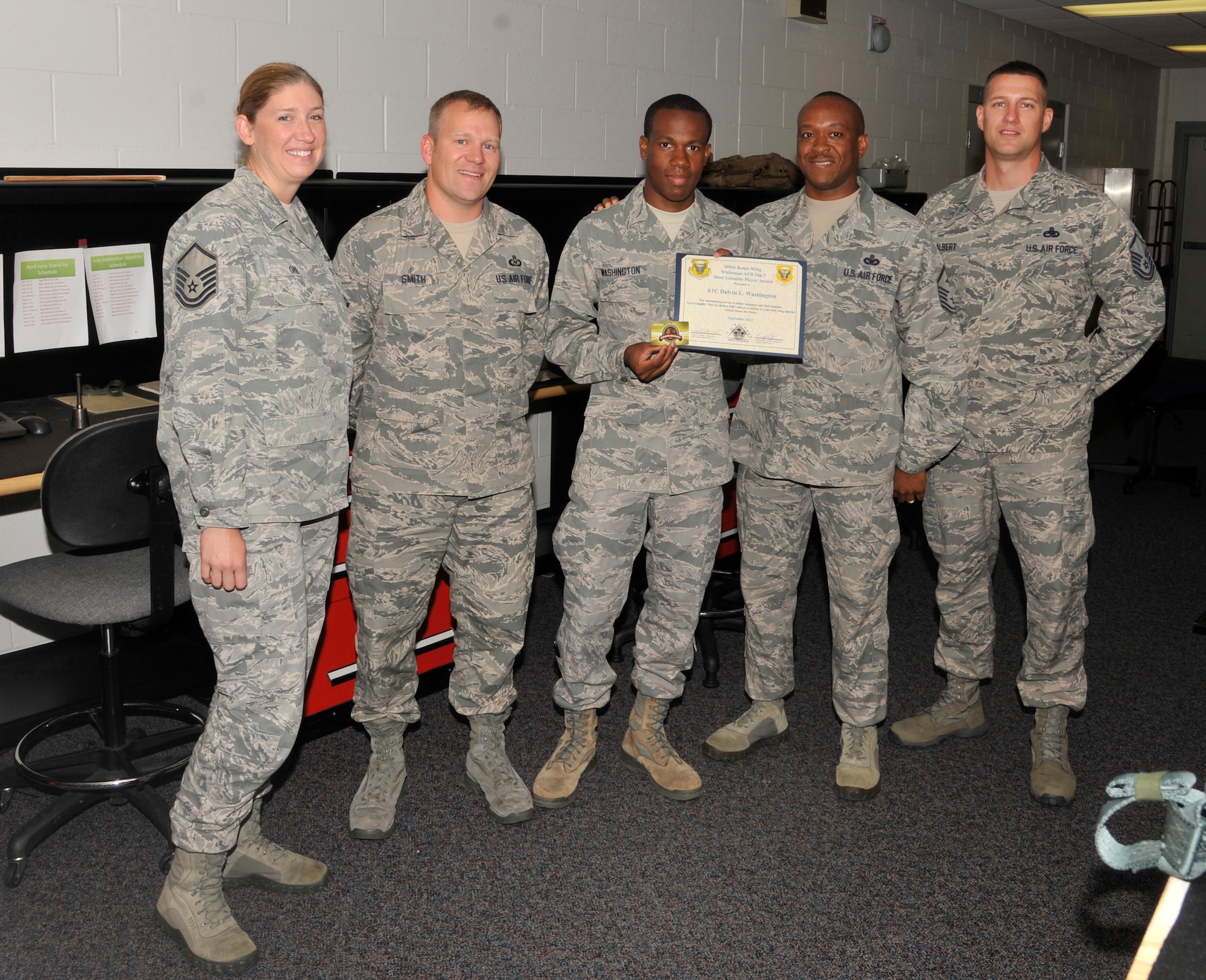 U.S. Air Force Airman 1st Class Dalvin Washington, 509th Operations Support Squadron aircrew flight equipment technician, receives the Whiteman Top III award at Whiteman Air Force Base, Mo., Sept. 19, 2013. Washington enrolled in classes immediately following a successful Career Development Course end of course test and has completed an English course. He also helped Airmen and their families move their belongings, as well as ran the prisoner of war/missing in action booth from 1 to 4 a.m. after working a full day shift. (U.S. Air Force photo by Airman 1st Class Keenan Berry/Released)