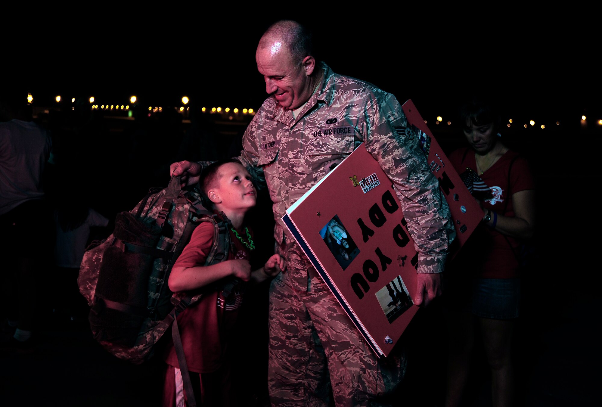 U.S. Air Force Senior Airman Charles Kotcher from the 442nd Security Forces Squadron shares a moment with his son after returning to Whiteman Air Force Base, Mo., Sept. 27, 2013, after a six-month-long deployment. Nearly 30 Airmen from the squadron deployed to Manas Air Base, Kyrgyzstan, to provide base defense support. (U.S. Air Force photo by Staff Sgt. Brigitte N. Brantley/Released)