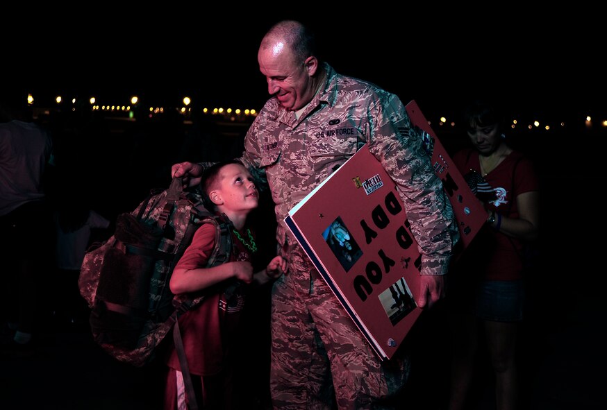 U.S. Air Force Senior Airman Charles Kotcher from the 442nd Security Forces Squadron shares a moment with his son after returning to Whiteman Air Force Base, Mo., Sept. 27, 2013, after a six-month-long deployment. Nearly 30 Airmen from the squadron deployed to Manas Air Base, Kyrgyzstan, to provide base defense support. (U.S. Air Force photo by Staff Sgt. Brigitte N. Brantley/Released)