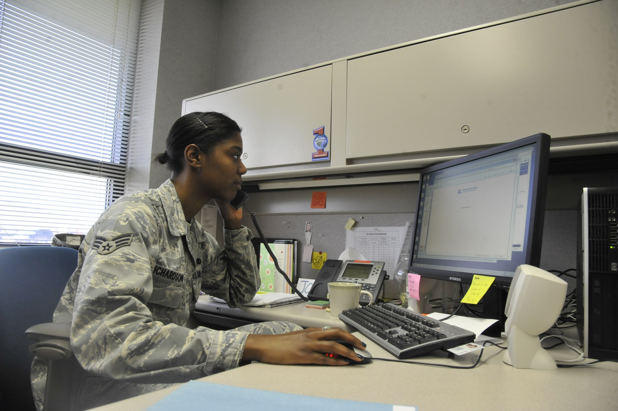 U.S. Air Force Senior Airman Joshenna Richardson, 442nd Force Support Squadron knowledge operations journeyman, assists a customer with a travel voucher in the Defense Travel System at Whiteman Air Force Base, Mo., Sept. 19, 2013. The co-seasoning training program is the Air Force Reserve Command’s method to progress an Airman from a 3- level to a 5-level within three months to a year. (U.S. Air Force photo by Airman 1st Class Keenan Berry/Released)