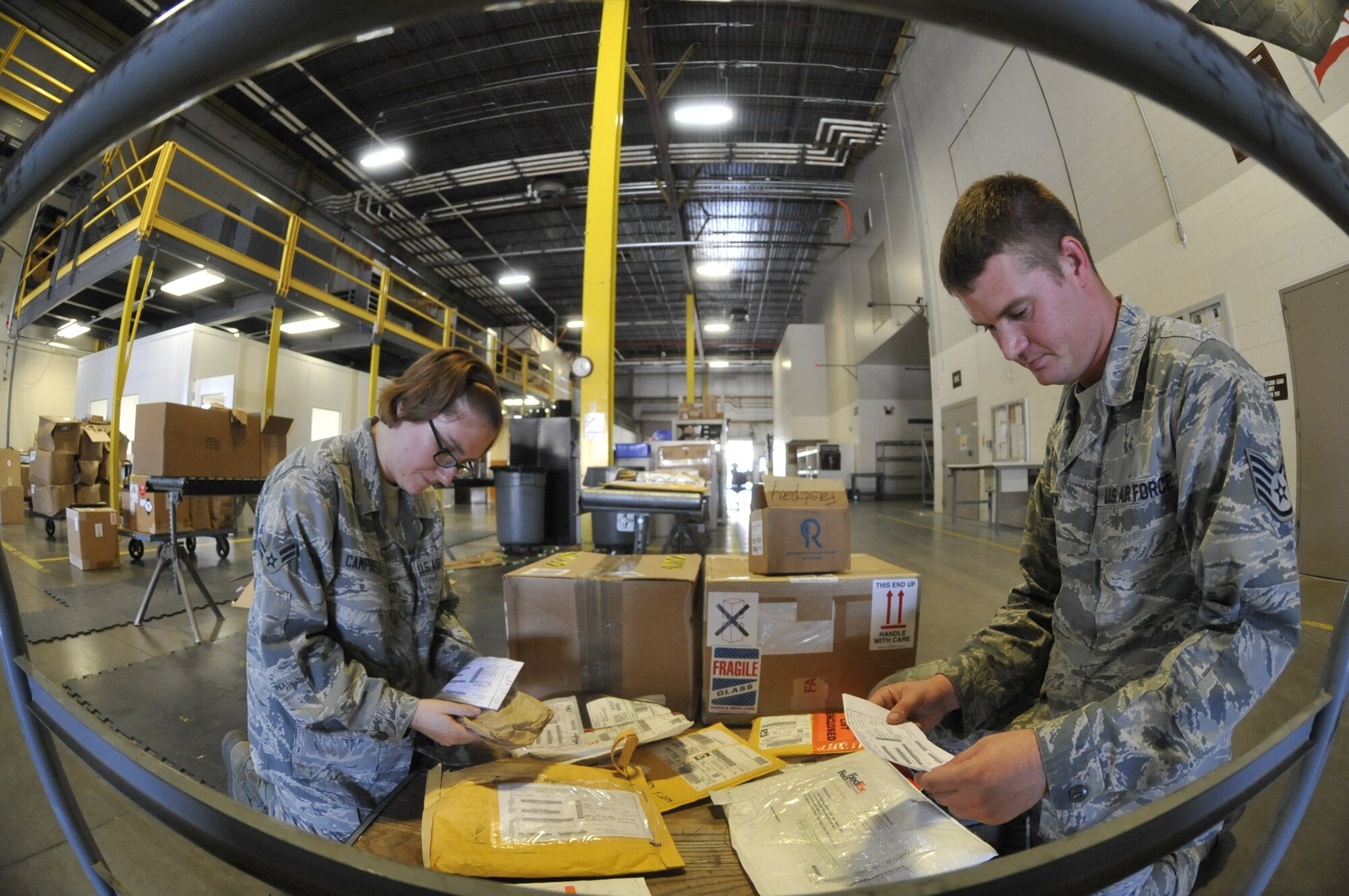 U.S. Air Force Airman 1st Class Hannah Campbell, left, and U.S. Air Force Staff Sgt. Chris Brockway, 442nd Logistics Readiness Squadron traffic management apprentices, process inbound shipments at Whiteman Air Force Base, Mo., Sept. 18, 2013. Inbound shipments must be processed in a timely manner so base customers can have their assets delivered or picked up. (U.S. Air Force photo by Airman 1st Class Keenan Berry/Released)