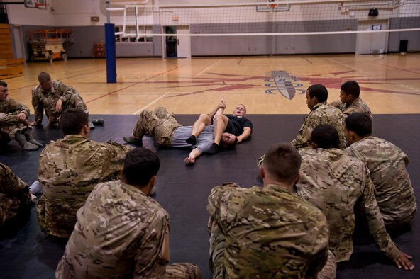 Tactical Air Control Party candidates watch as instructors demonstrate an arm bar during combative skills training at the Aderholt Fitness Center on Hurlburt Field, Fla., Sept. 17, 2013. The candidates went through a five-day combative training course as a part of their technical training. (U.S. Air Force photo/Senior Airman Krystal M. Garrett)