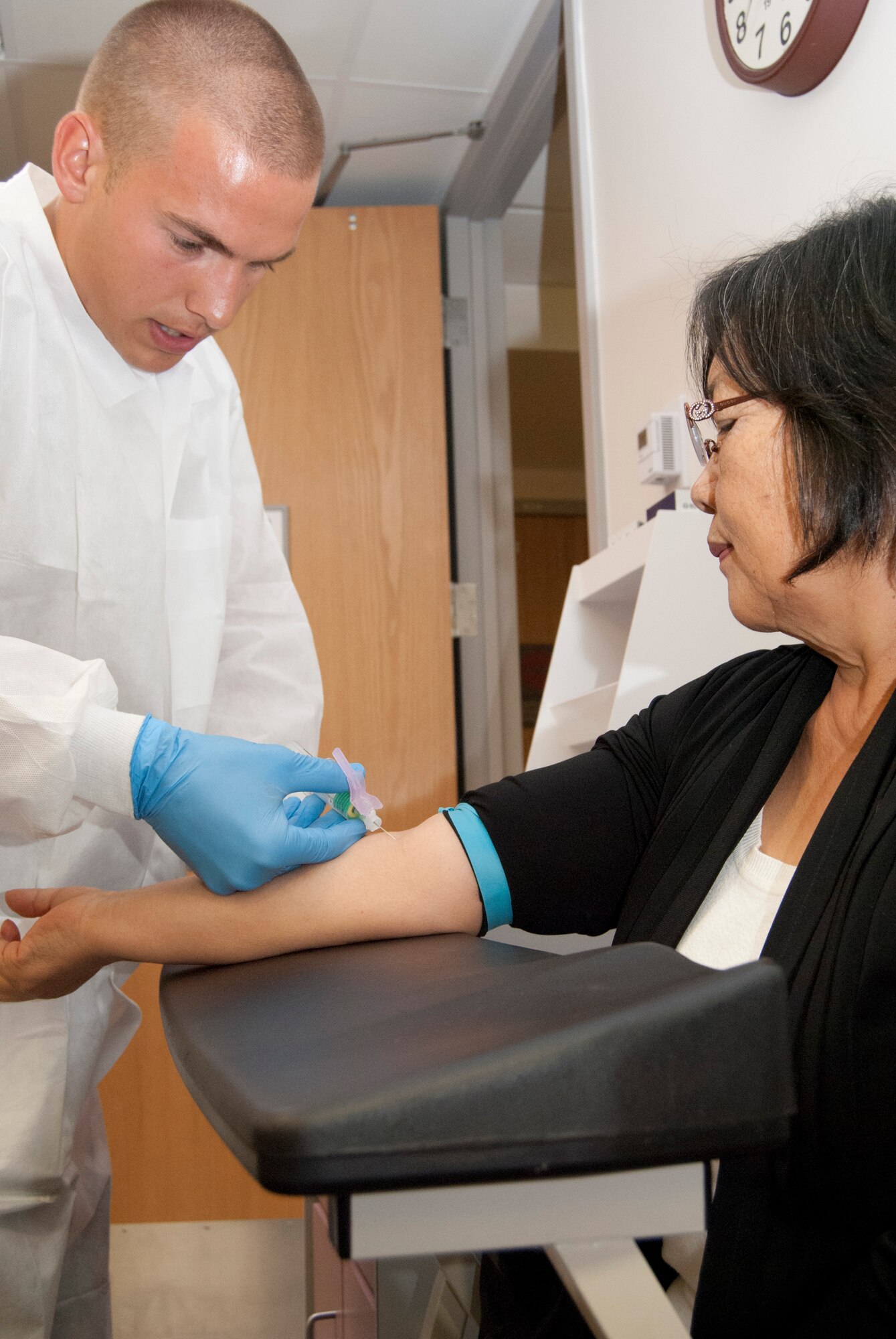 Senior Airman Josh Underly draws blood from Chun Eriksen in the 10th Medical Group Clinic at the Air Force Academy Sept. 25, 2013. The 10th Medical Group Laboratory has a 97-percent customer satisfaction rate, Lab Flight Commander Lt. Col. Nathan Johnson said. Underly, a lab technician with the 10th Medical Support Squadron, has been at the Academy a little more than a year. (U.S. Air Force photo/Don Branum)